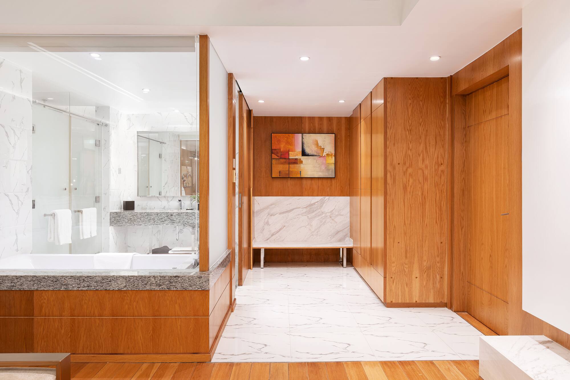 a bathroom with wood cabinets and marble floor