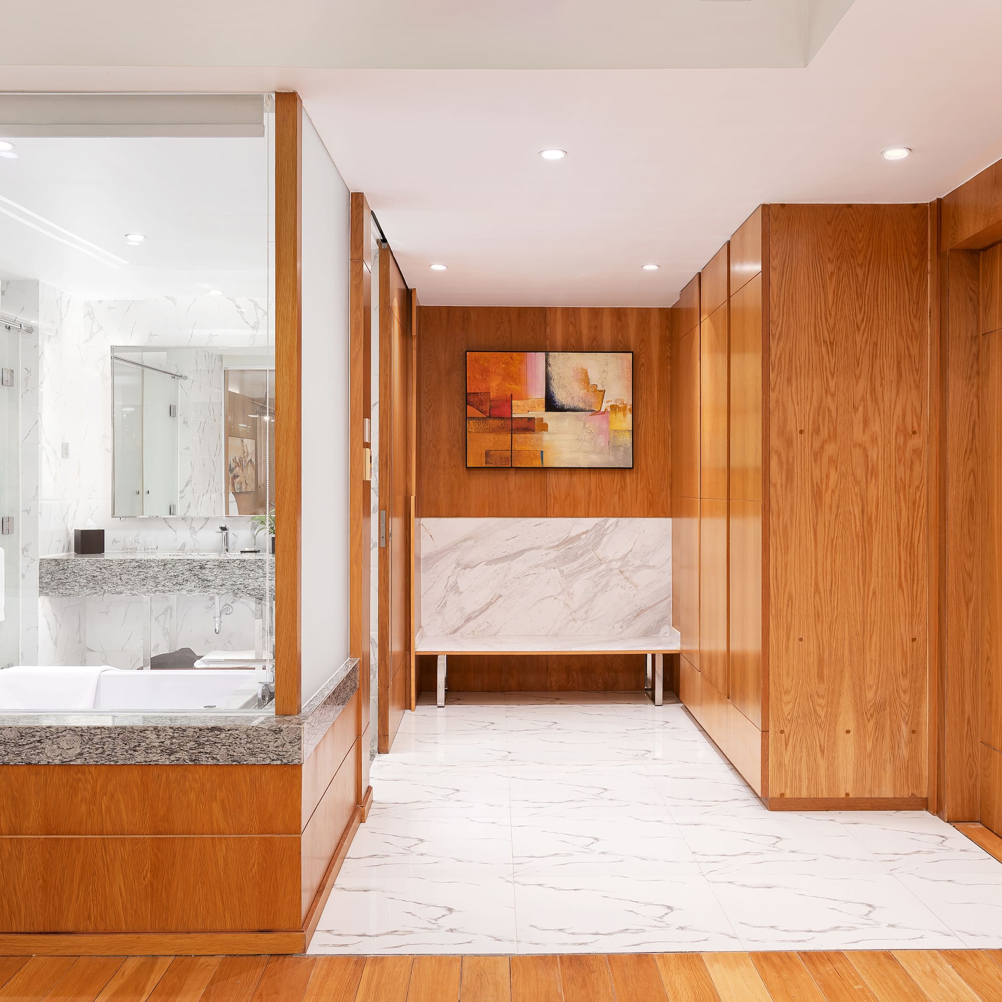 a bathroom with wood cabinets and marble floor