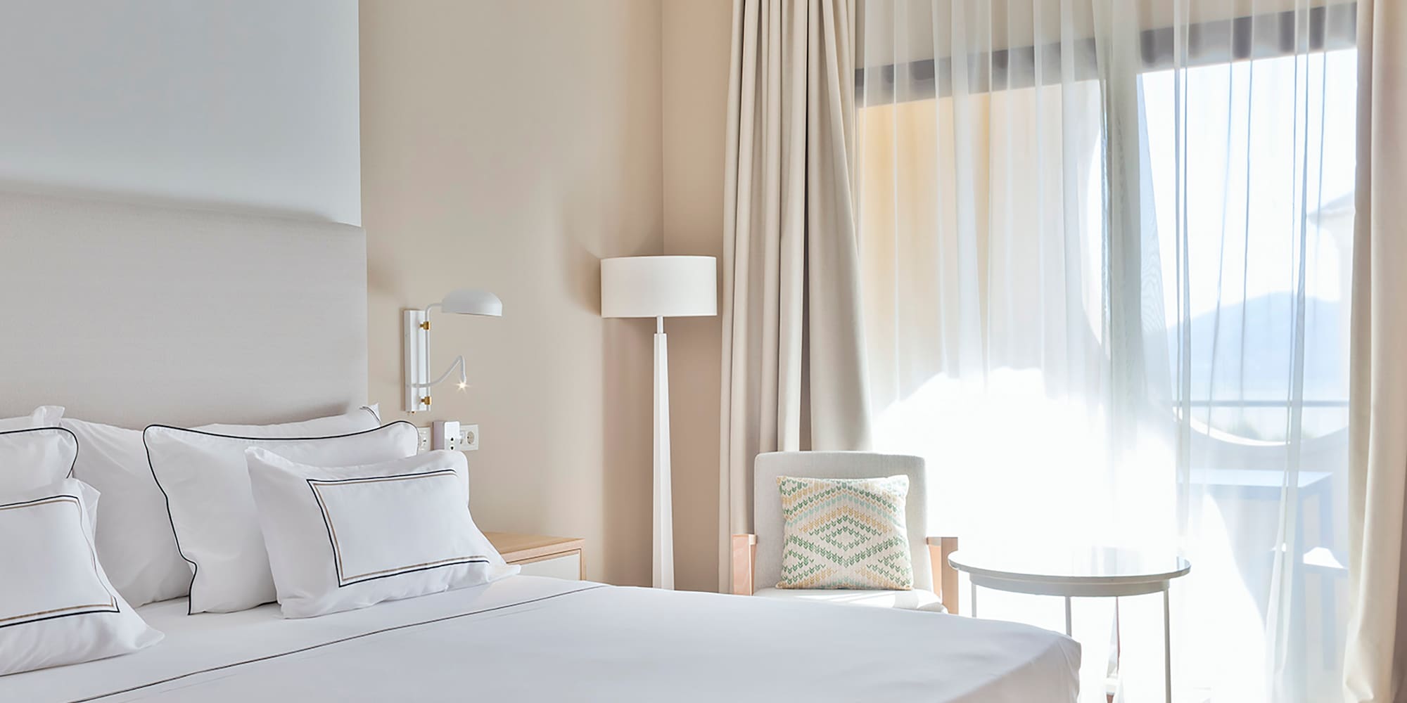 a bed with a bench and a lamp