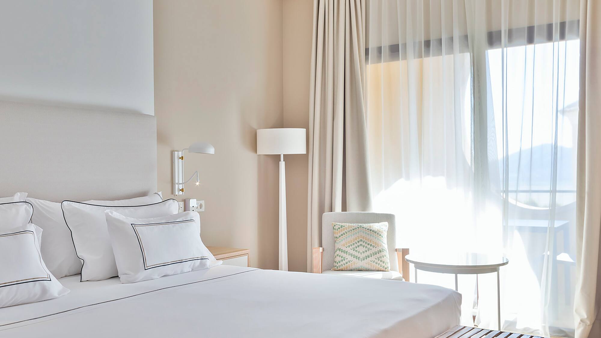 a bed with a bench and a lamp