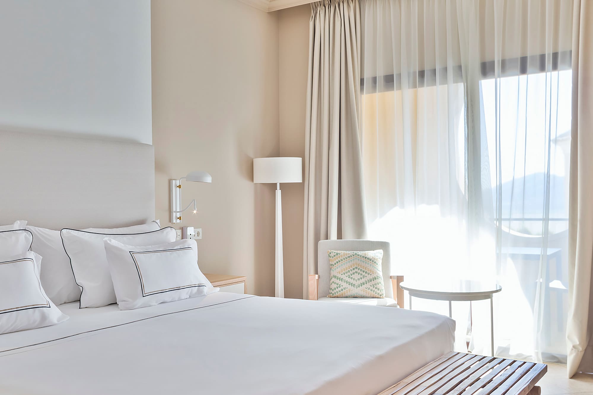 a bed with a bench and a lamp