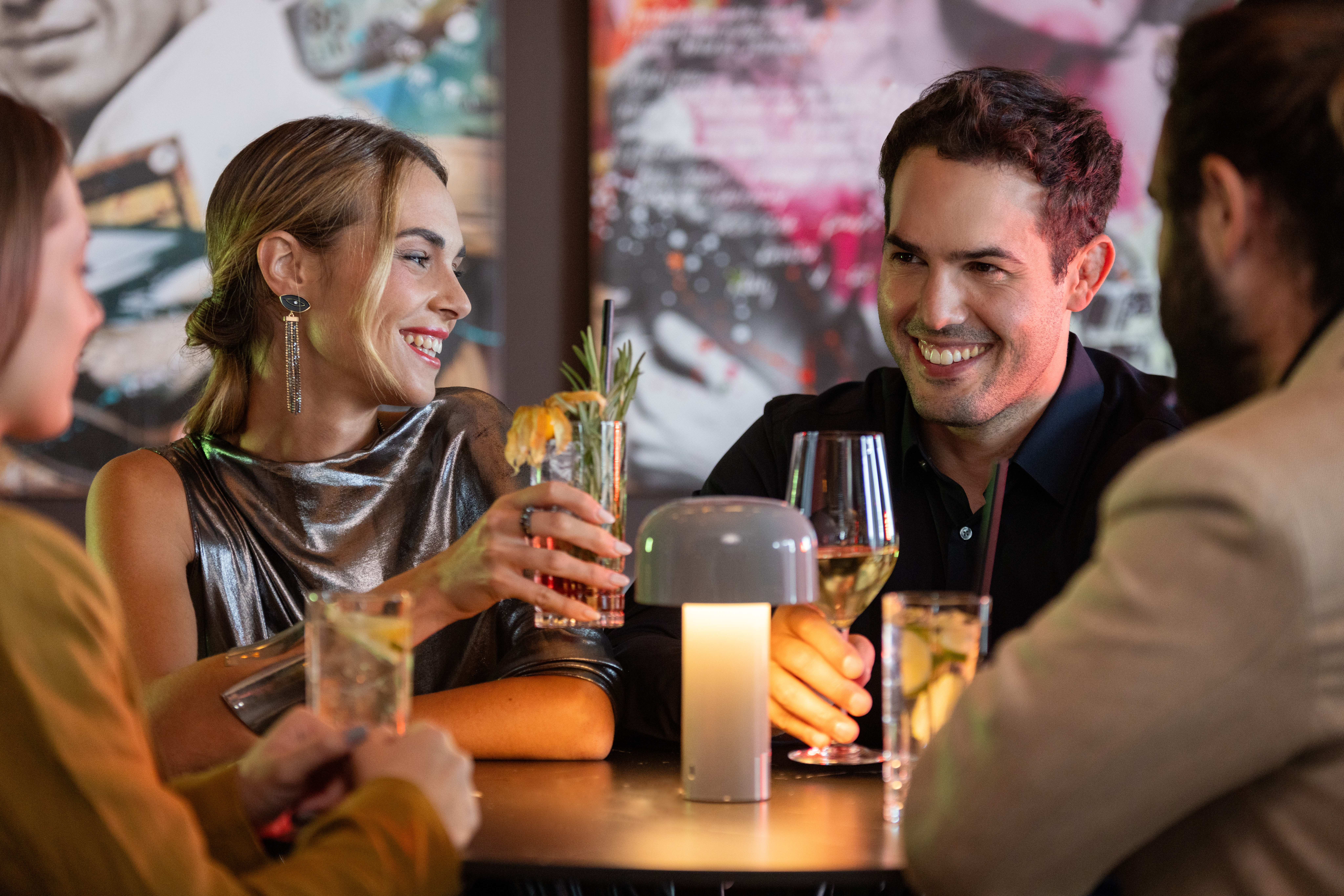 A group of people gathered around a table, each holding a drink.