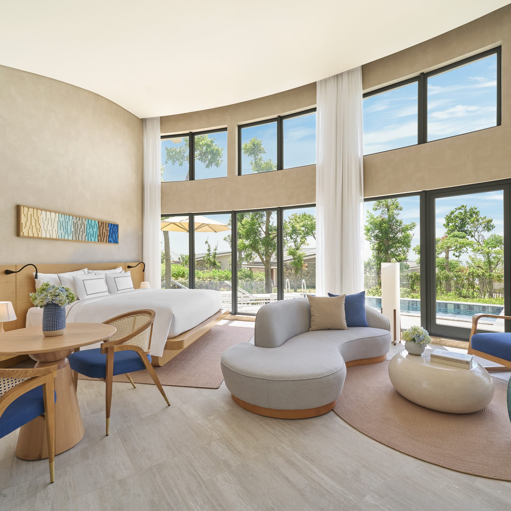 Luxury resort suite with modern design, king bed, and pool view windows.