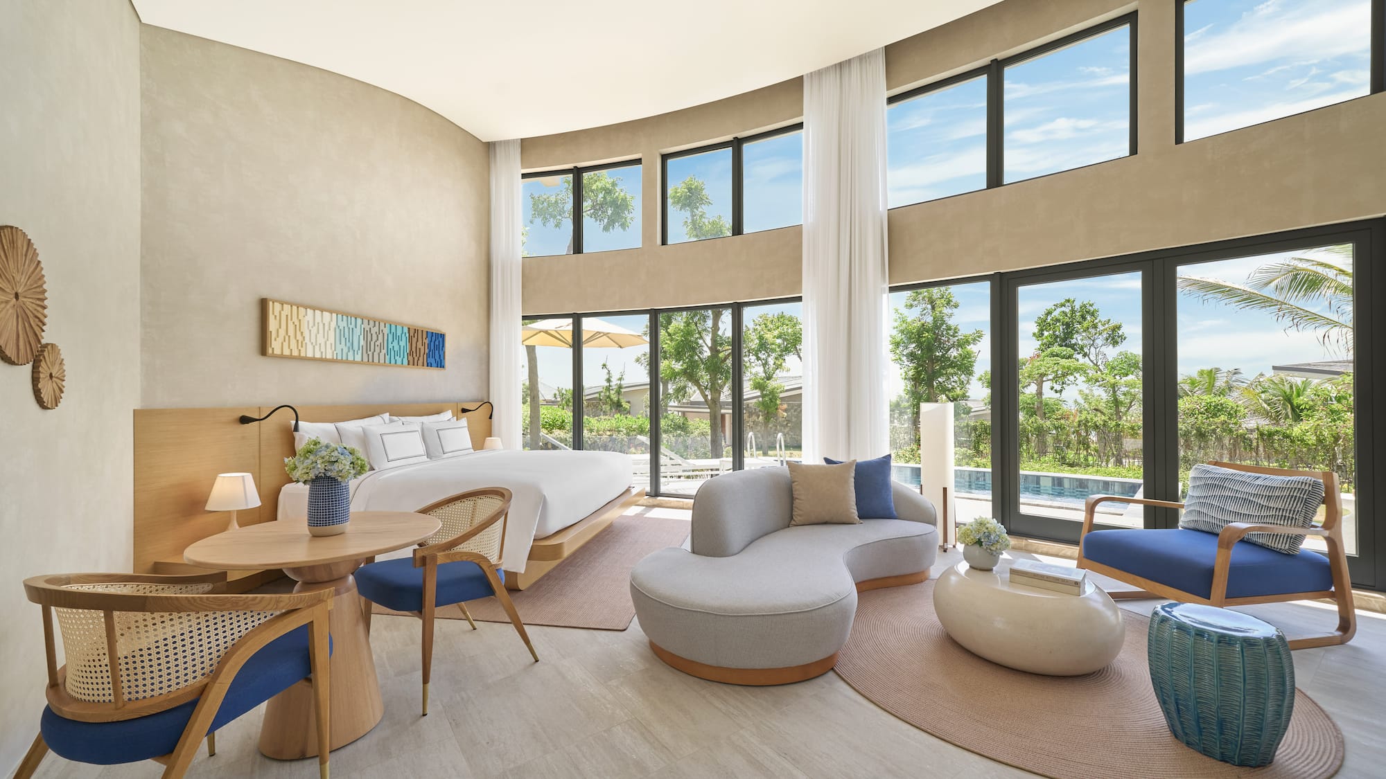 Luxury resort suite with modern design, king bed, and pool view windows.