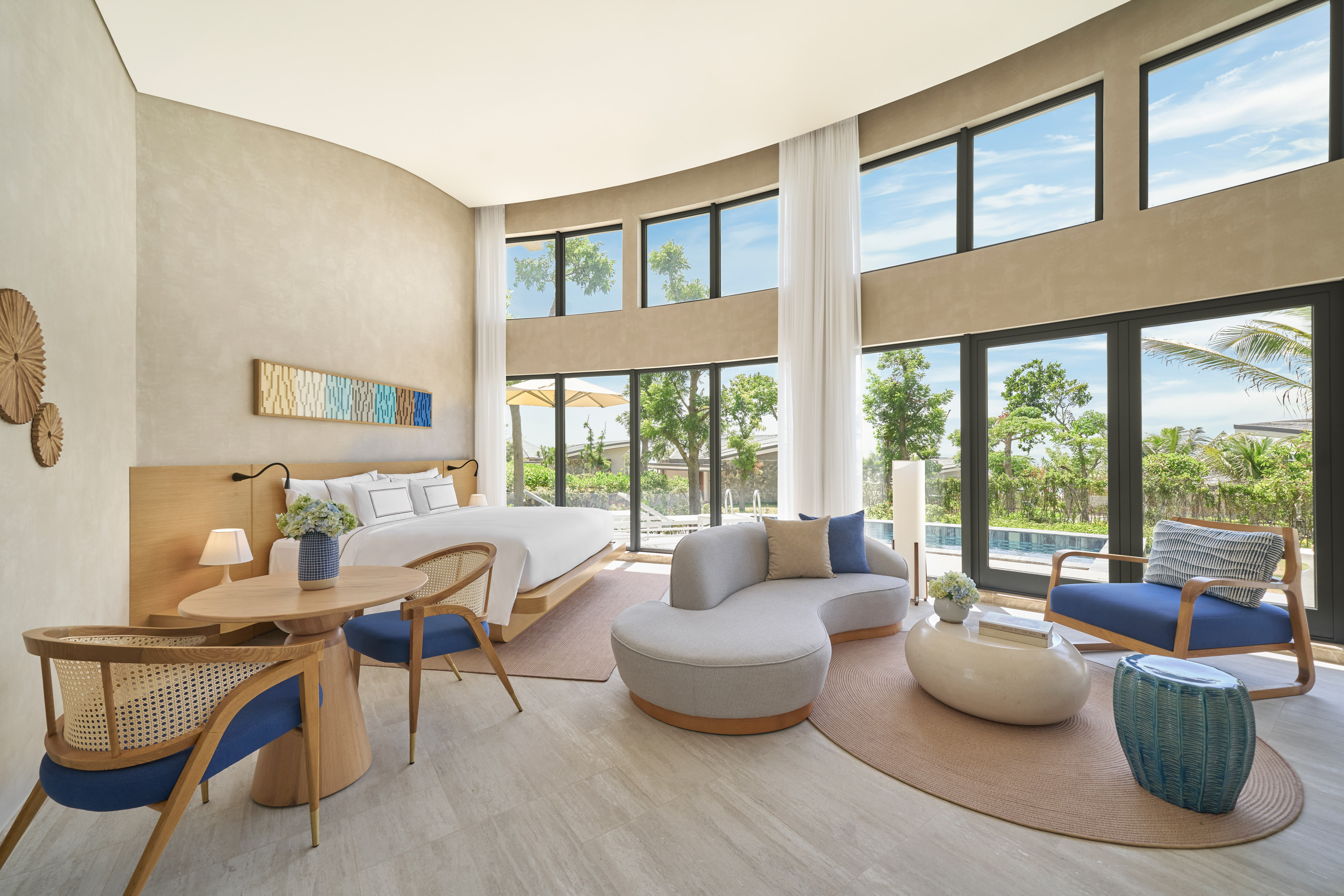 Luxury resort suite with modern design, king bed, and pool view windows.
