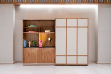 a shelf with books and a lamp in front of it