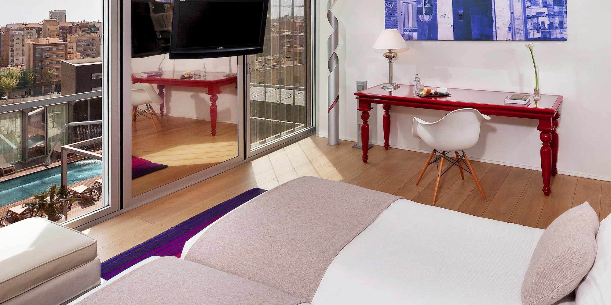 a room with a bed and a desk and a mirror