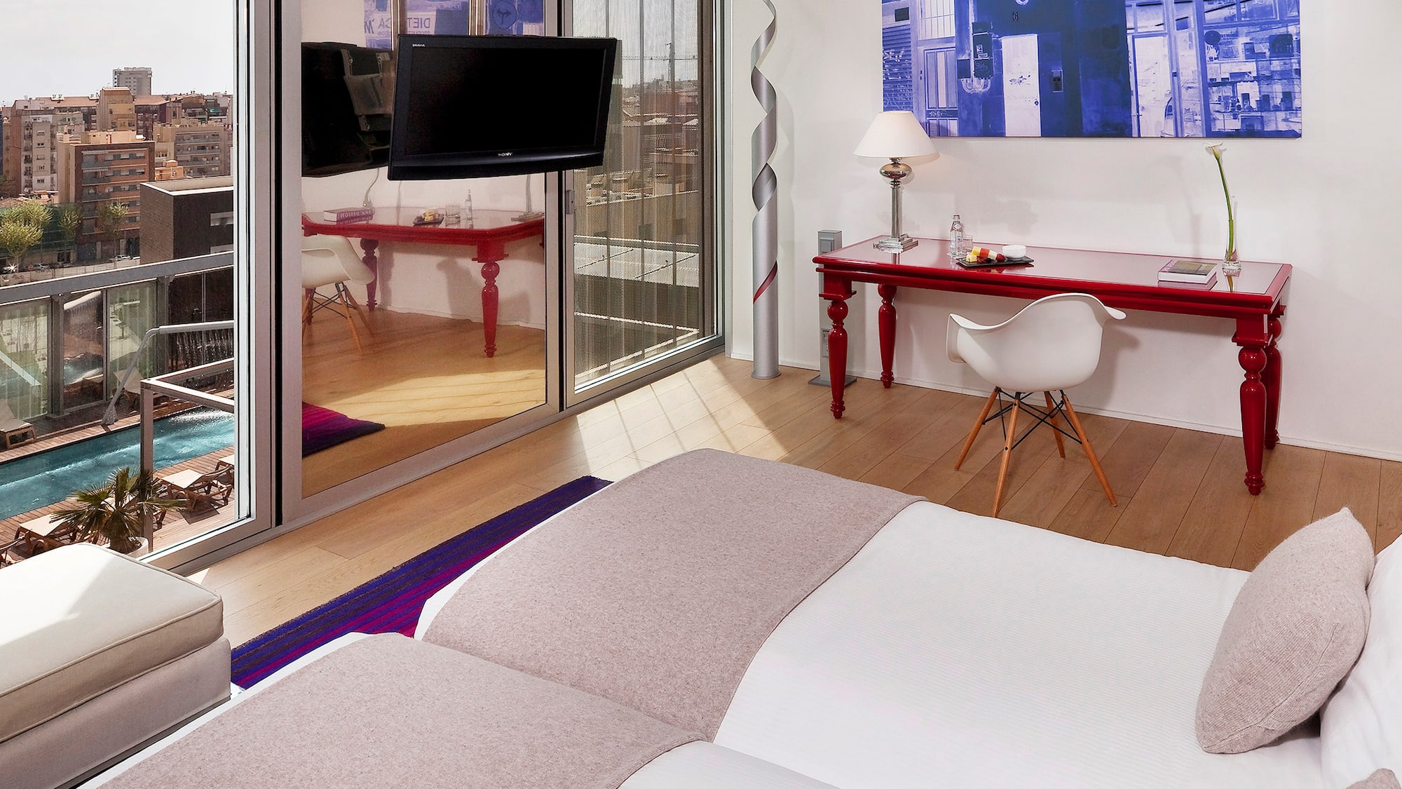 a room with a bed and a desk and a mirror