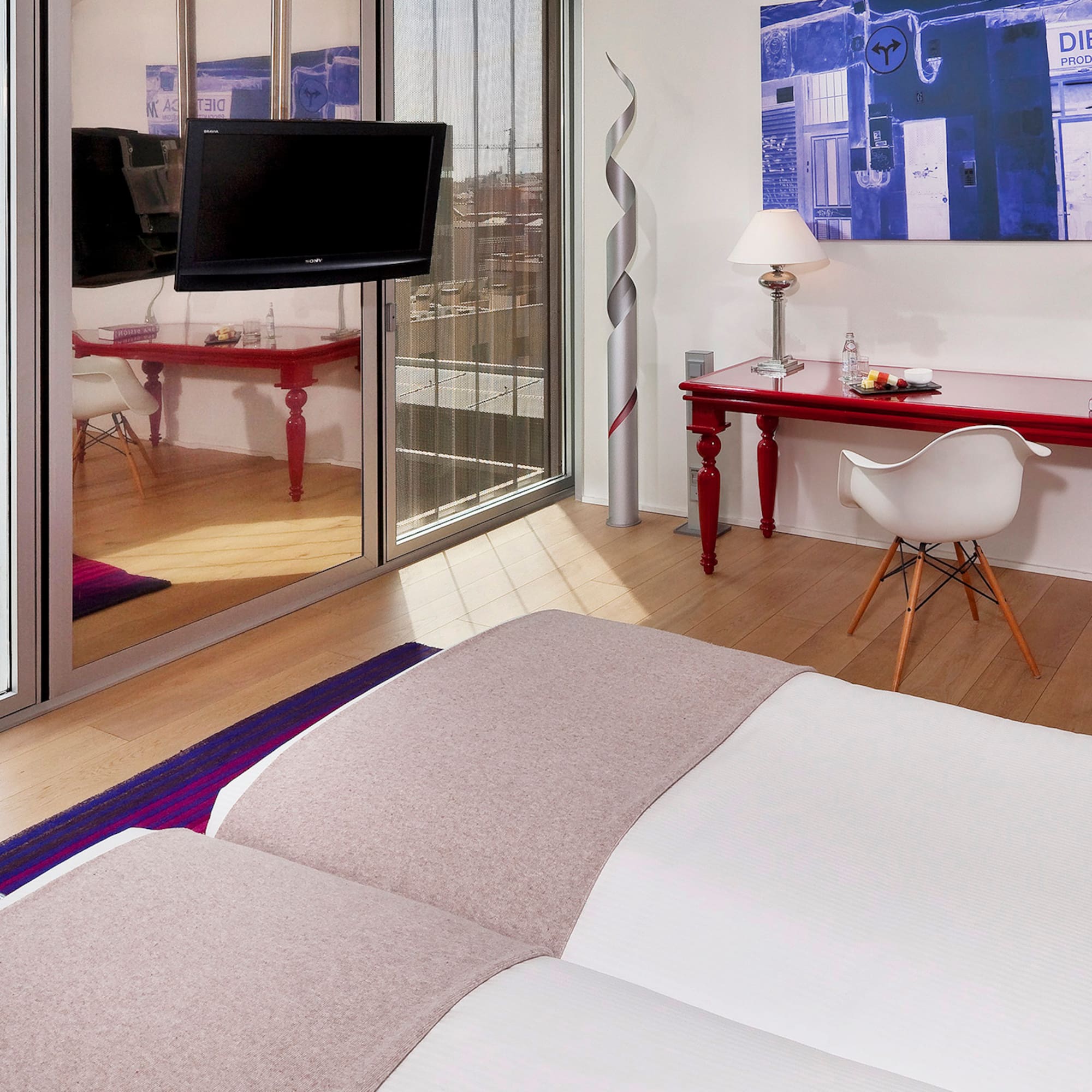 a room with a bed and a desk and a mirror