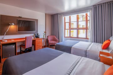 a room with two beds and a tv