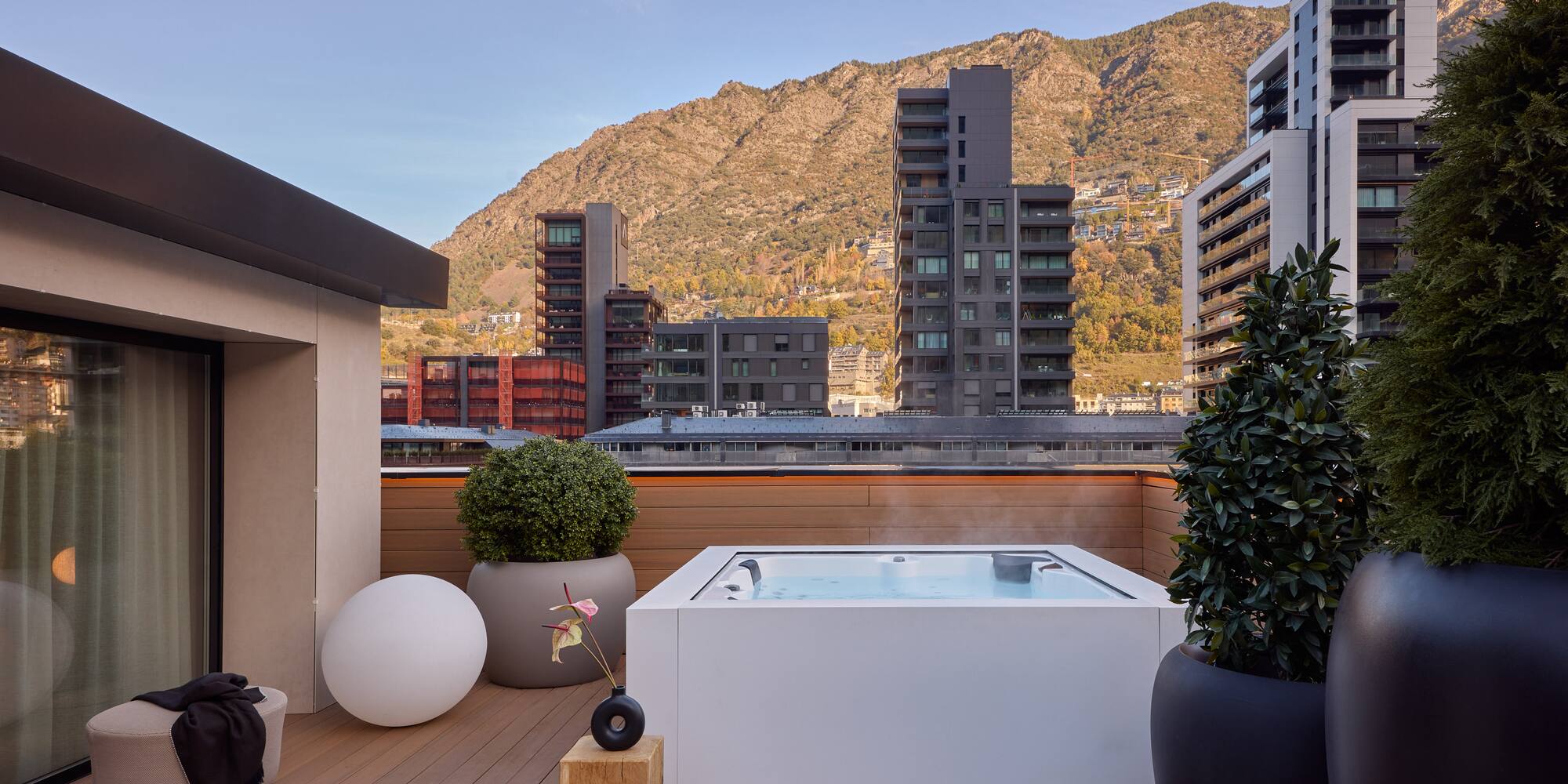 a hot tub on a deck with a mountain in the background