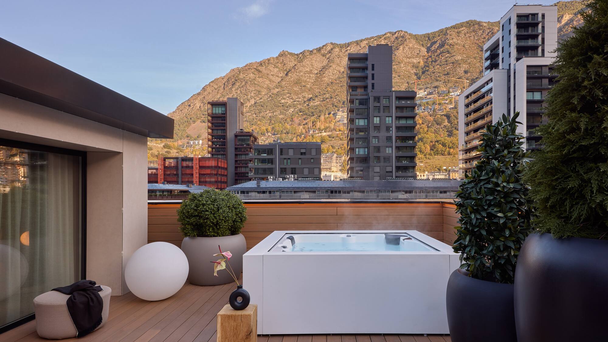 a hot tub on a deck with a mountain in the background