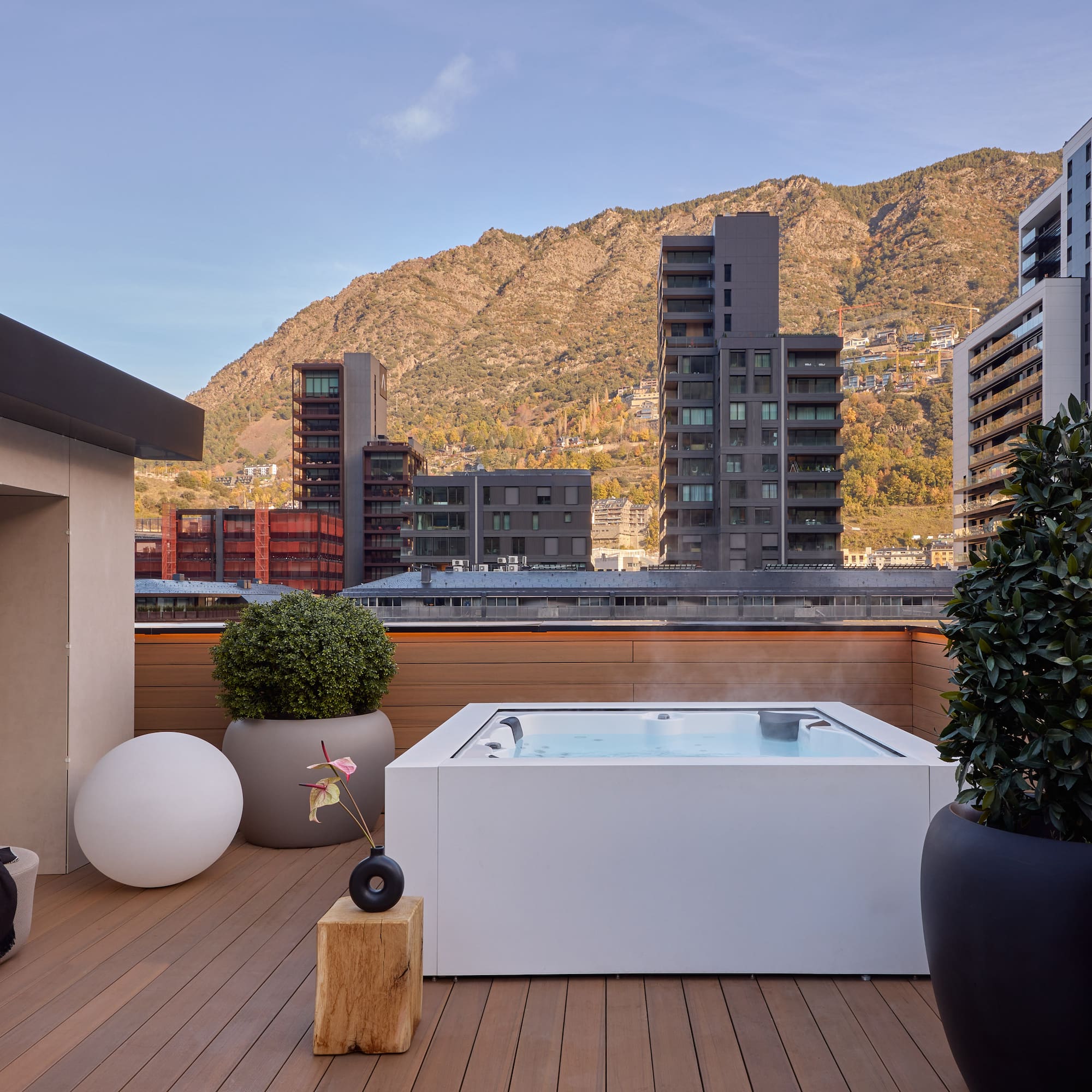 a hot tub on a deck with a mountain in the background