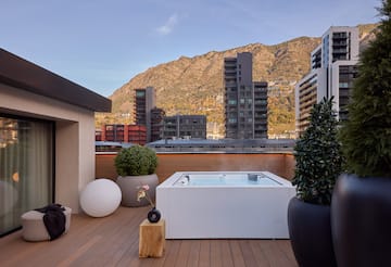a hot tub on a deck with a mountain in the background