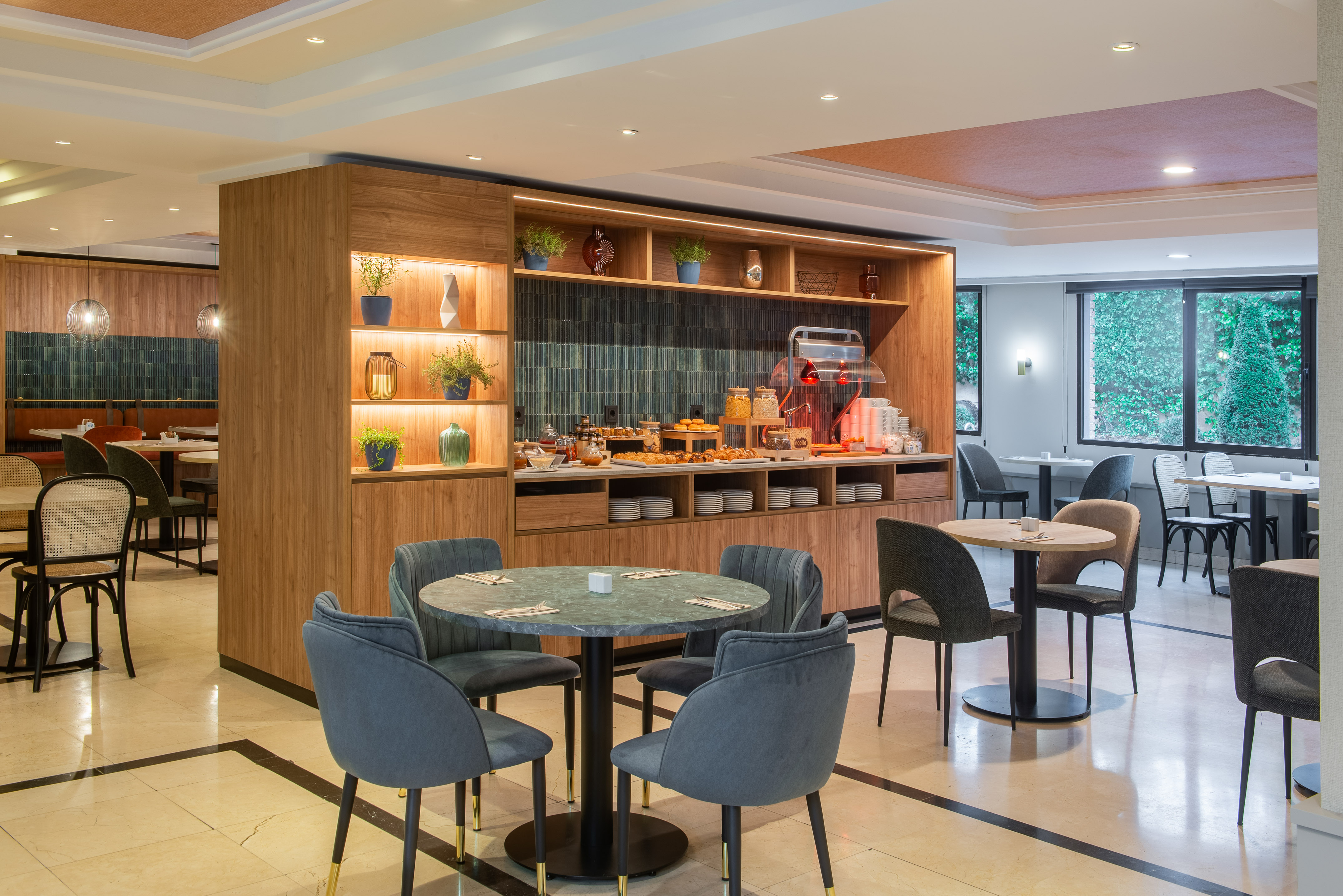Modern hotel breakfast buffet with pastries, cereals, and stylish dining area.