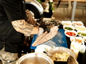 a person cutting fish on a cutting board