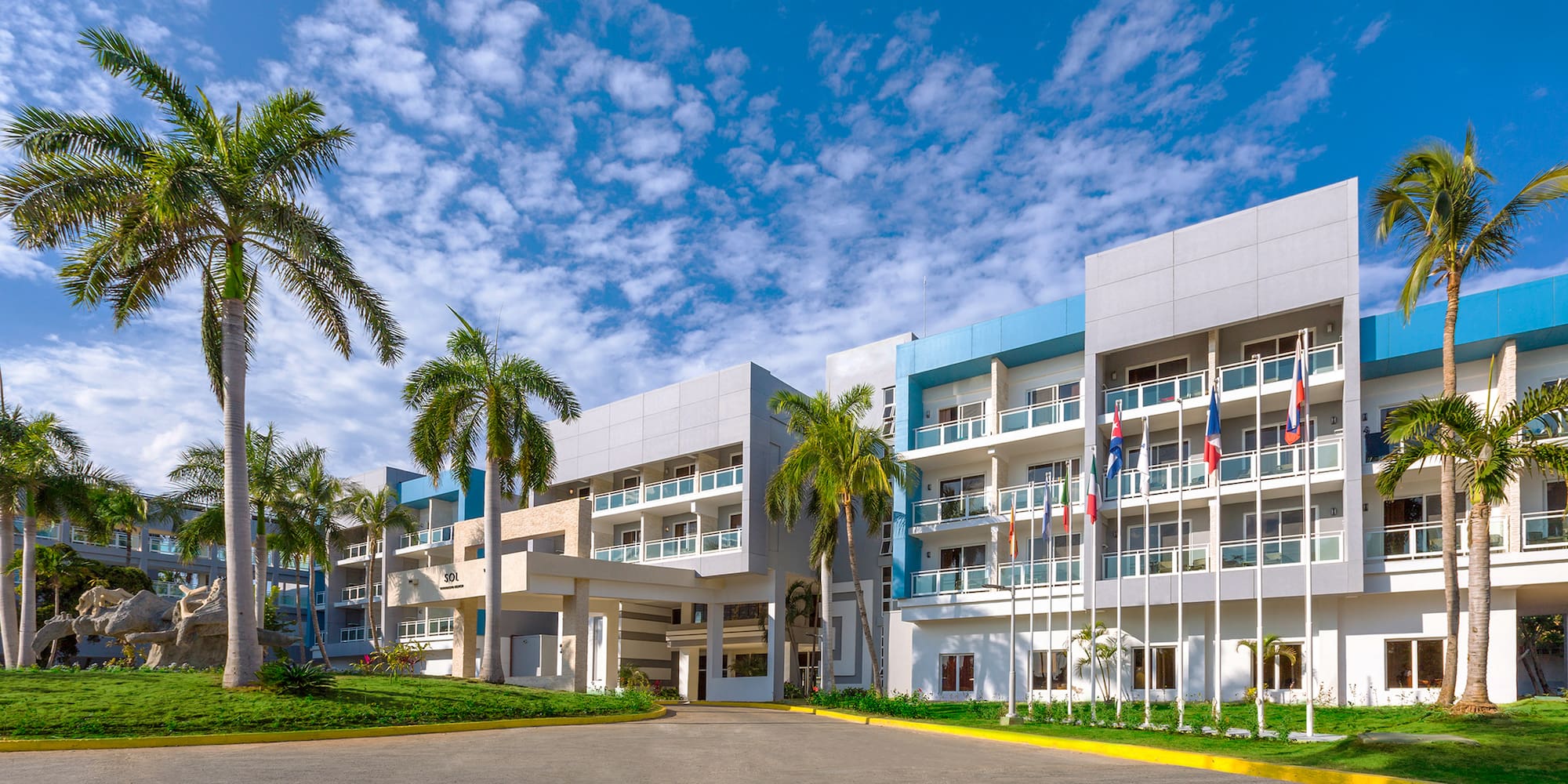 a building with palm trees and flags