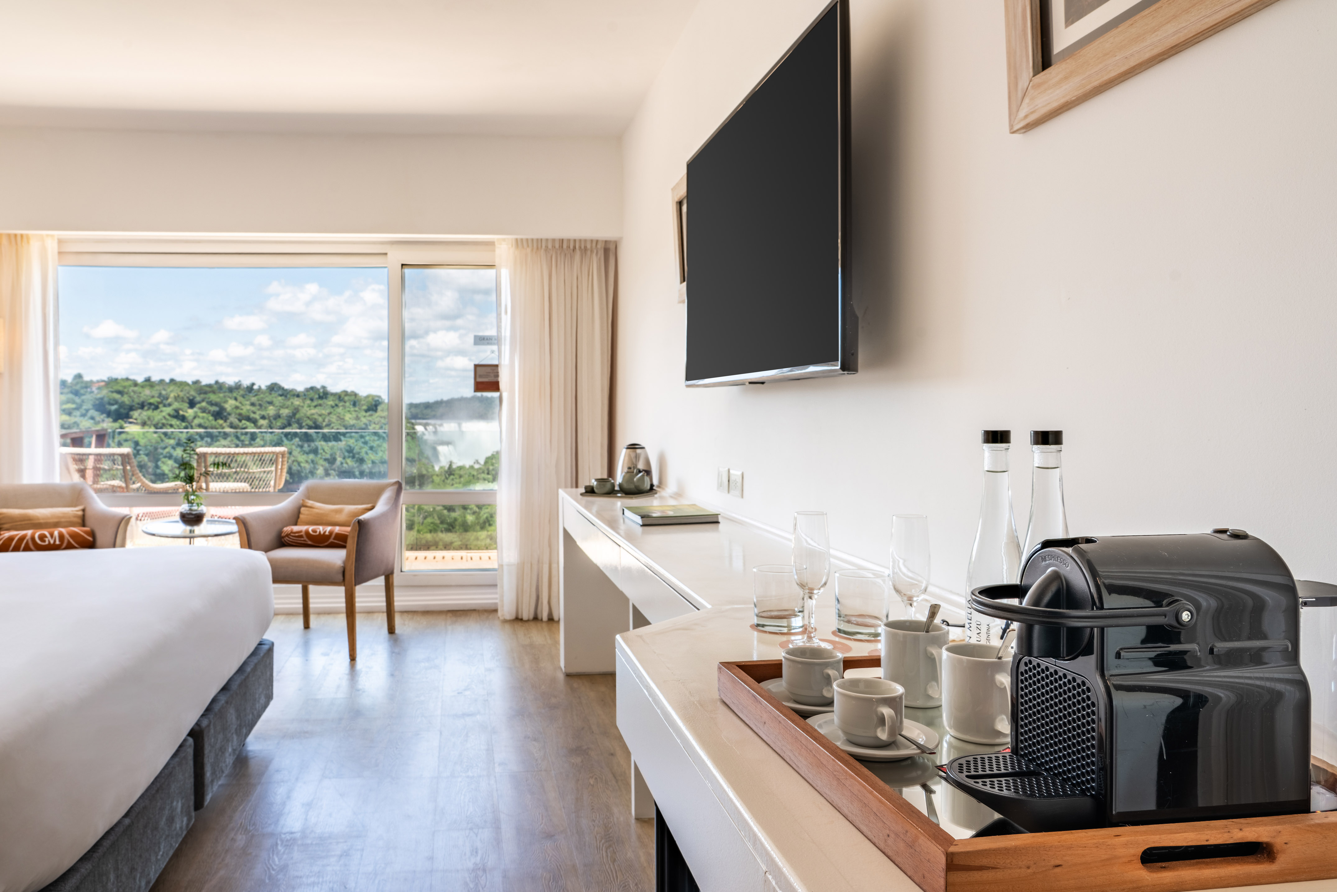 Hotel suite with Iguazu Falls view, bed, and Nespresso coffee machine.