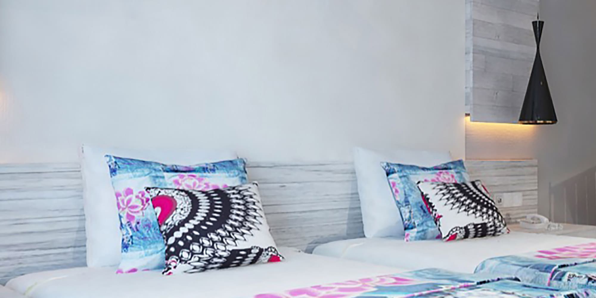 a bed with pillows and a wallpaper on the wall