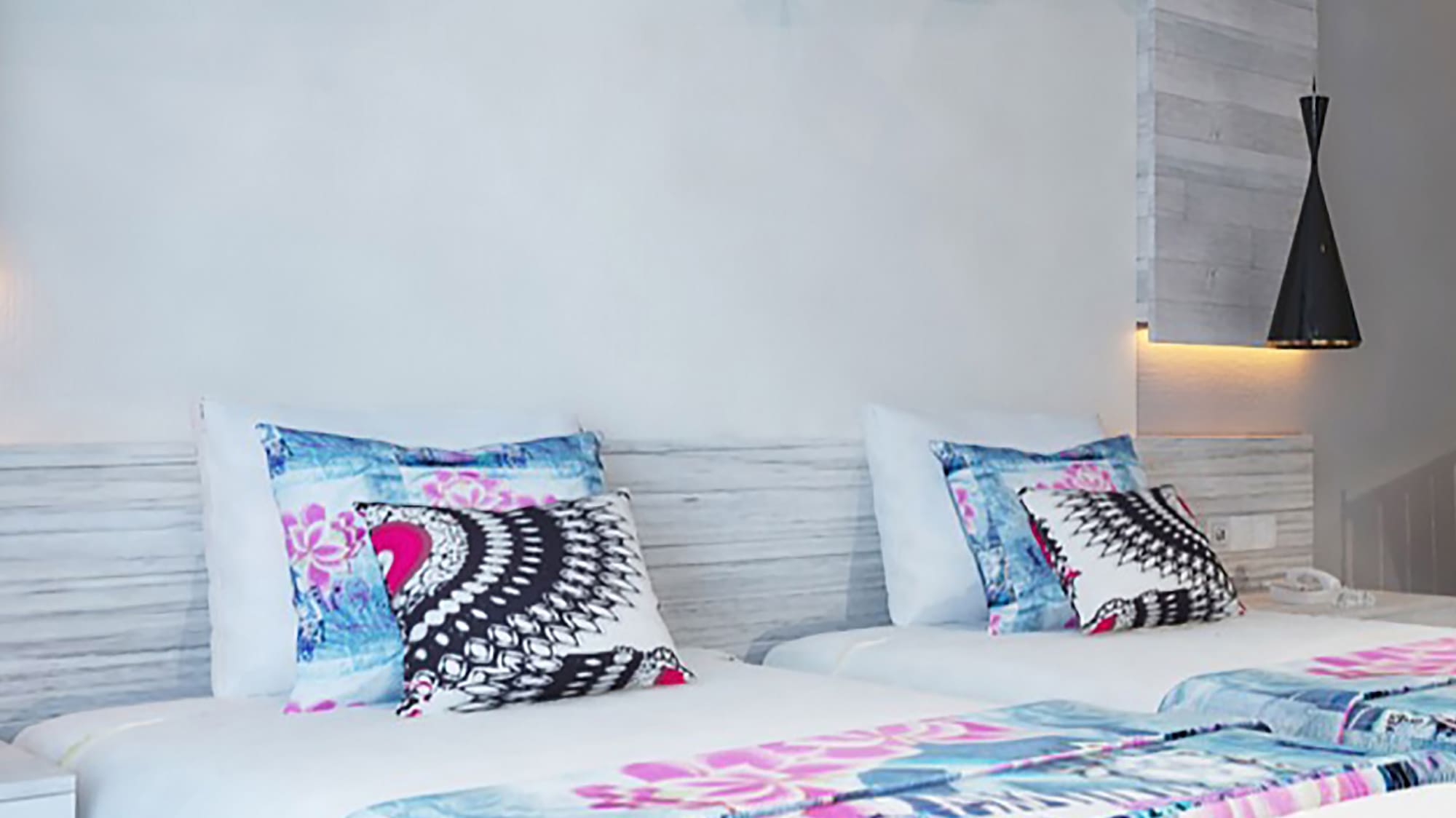 a bed with pillows and a wallpaper on the wall