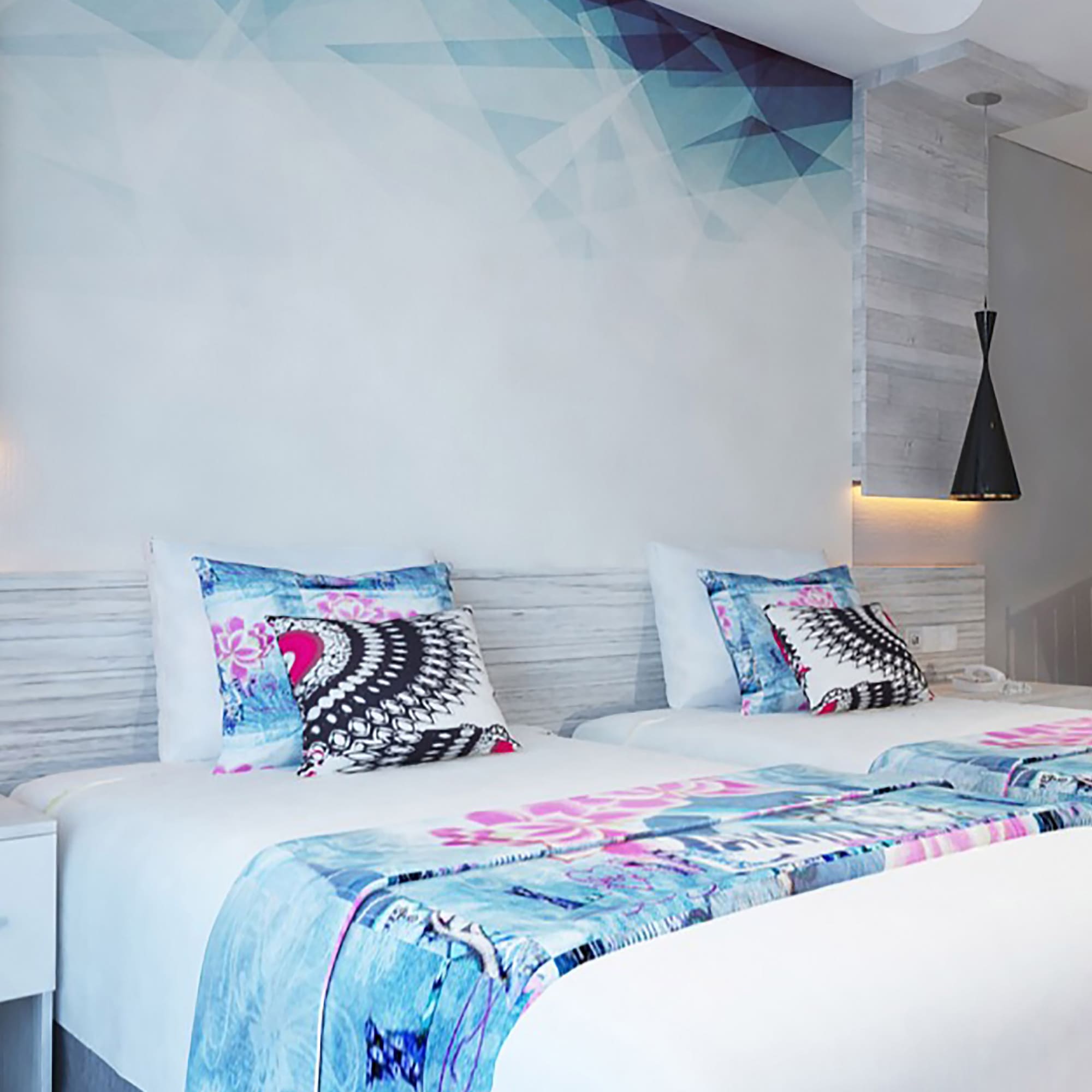 a bed with pillows and a wallpaper on the wall