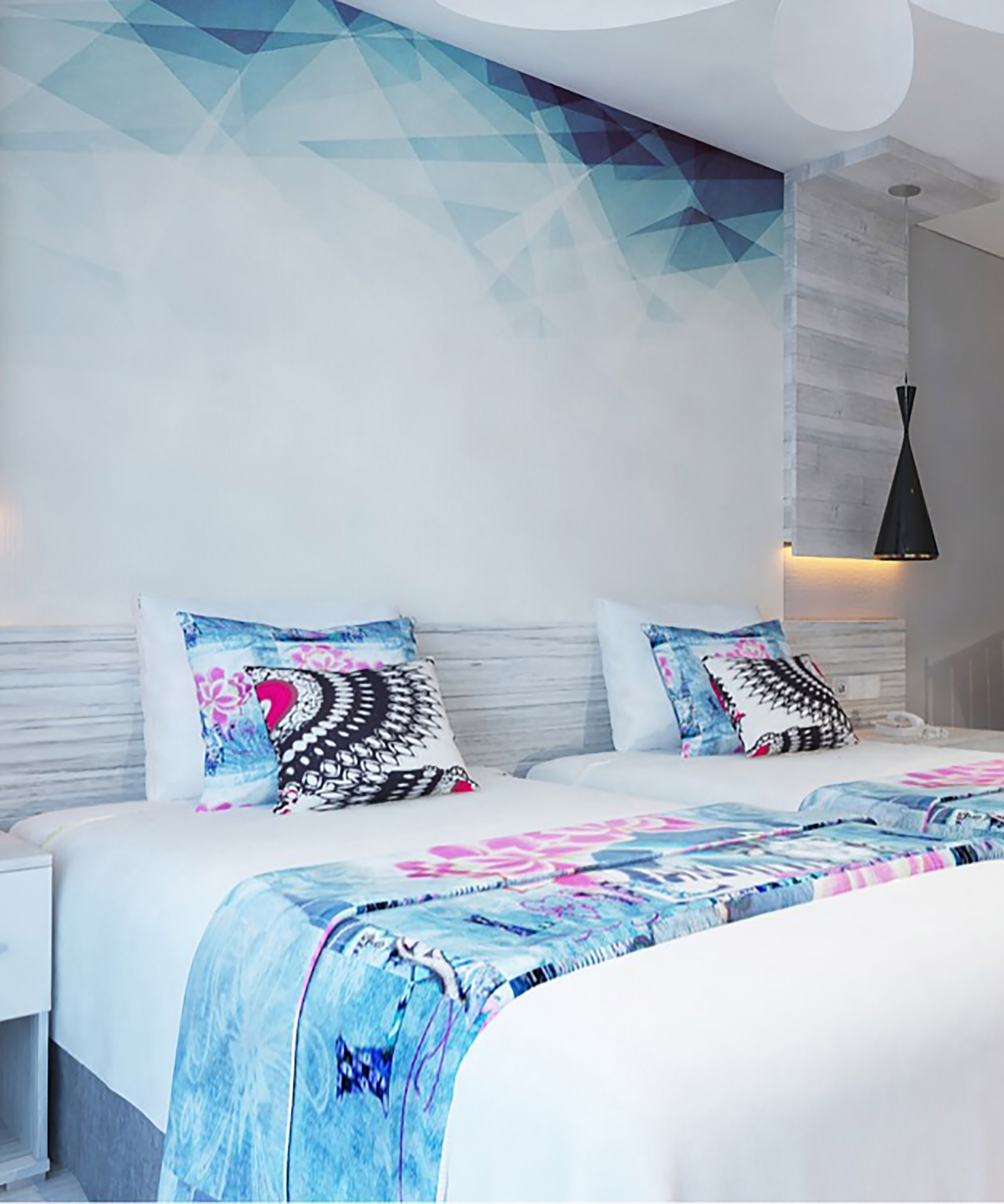 a bed with pillows and a wallpaper on the wall