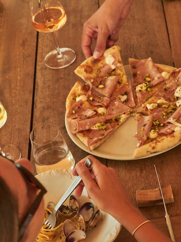 a person eating pizza with a knife and fork