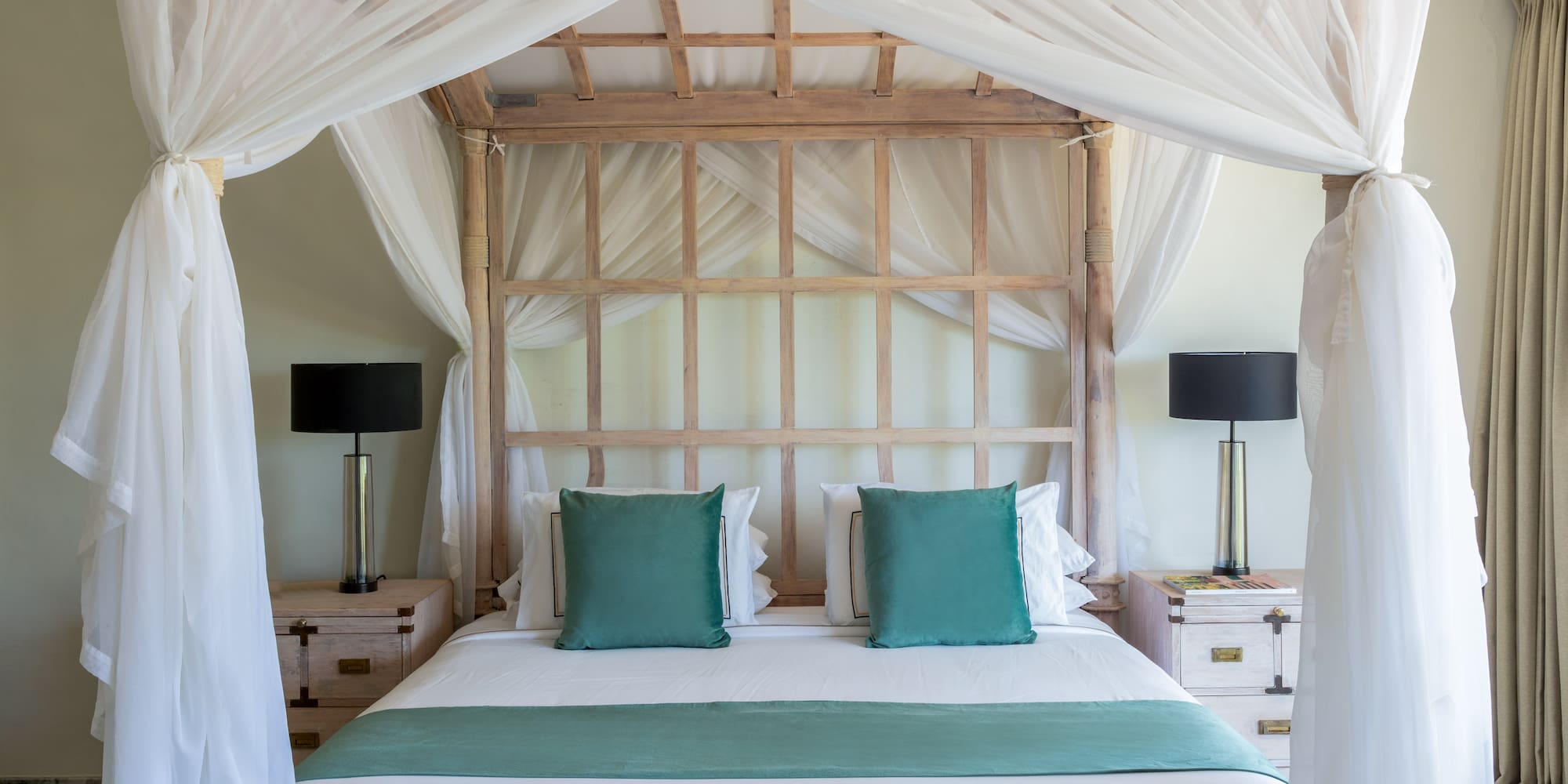 a bed with white curtains and a white canopy over it