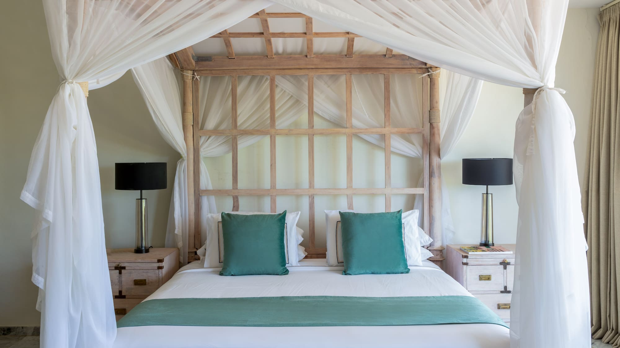 a bed with white curtains and a white canopy over it