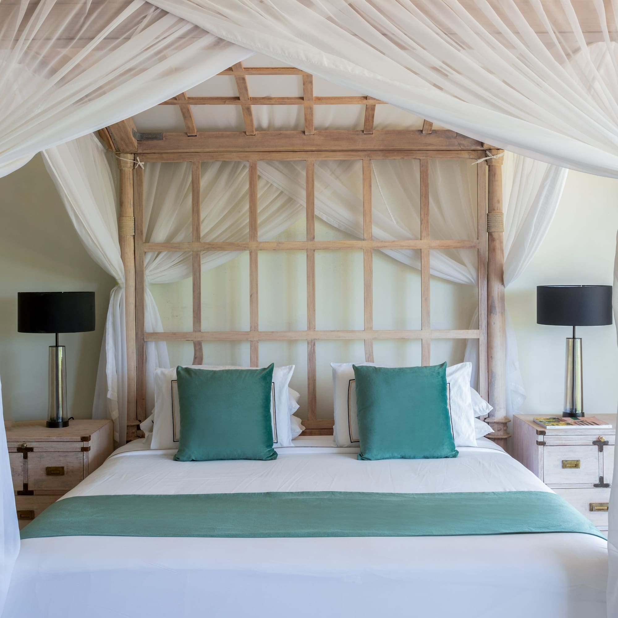 a bed with white curtains and a white canopy over it