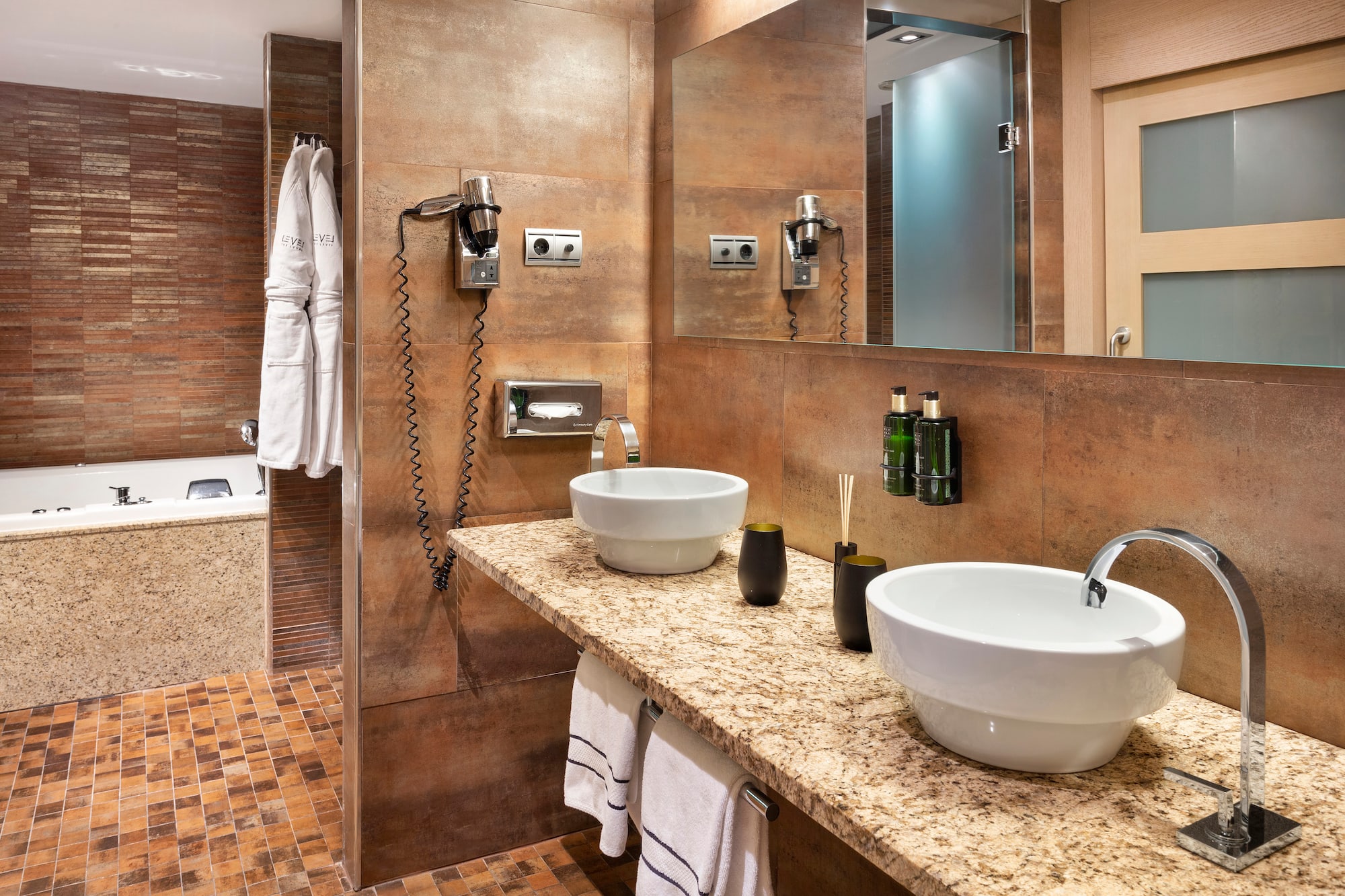 a bathroom with marble countertop sinks and a bathtub