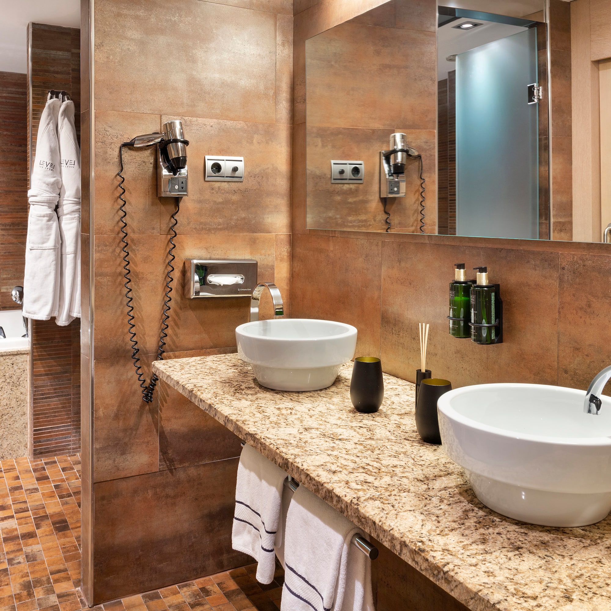 a bathroom with marble countertop sinks and a bathtub