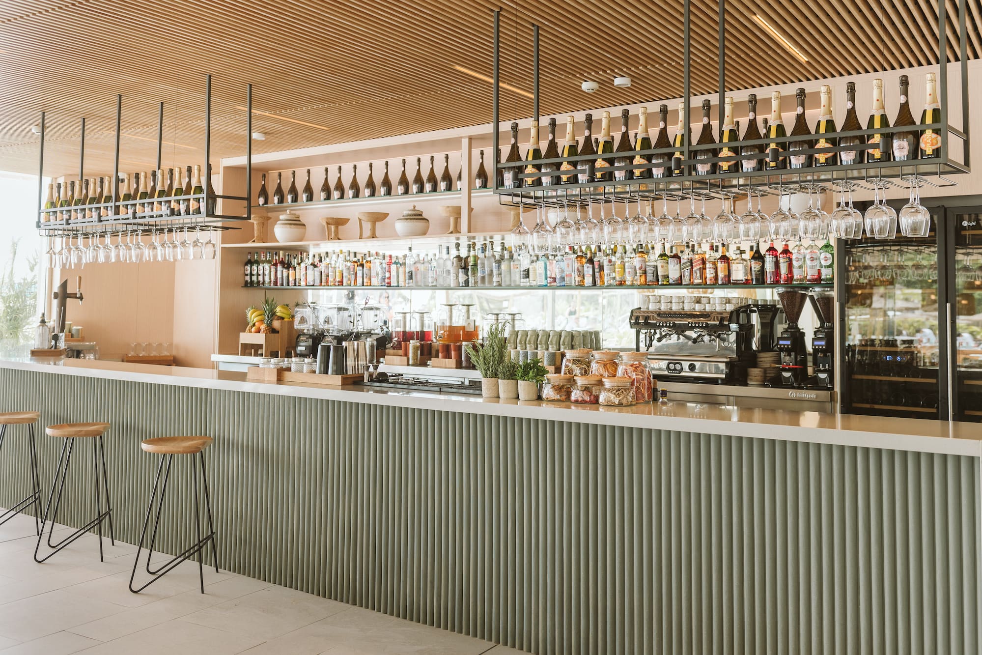 a bar with bottles and glasses from the ceiling