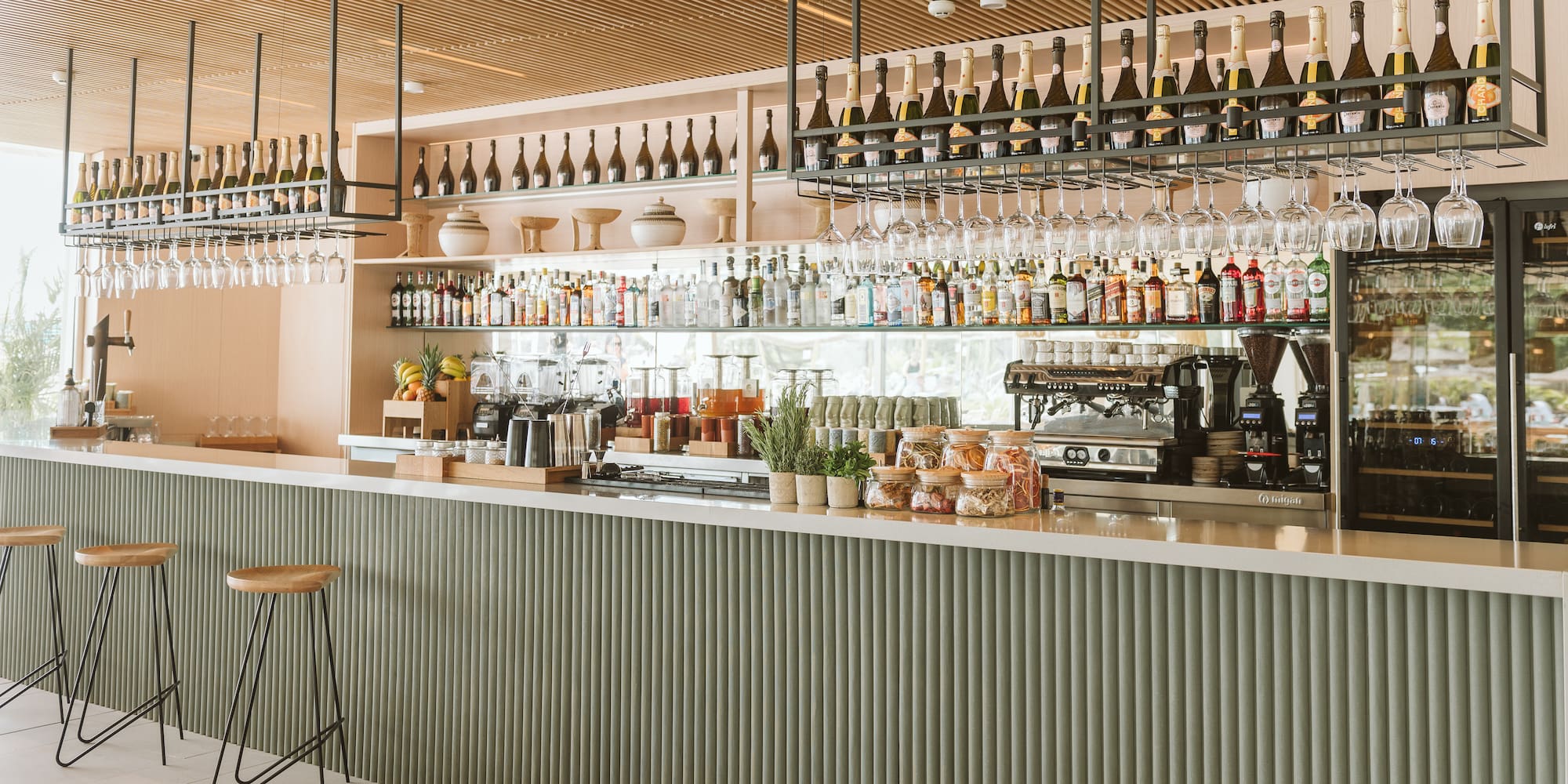 a bar with bottles and glasses from the ceiling