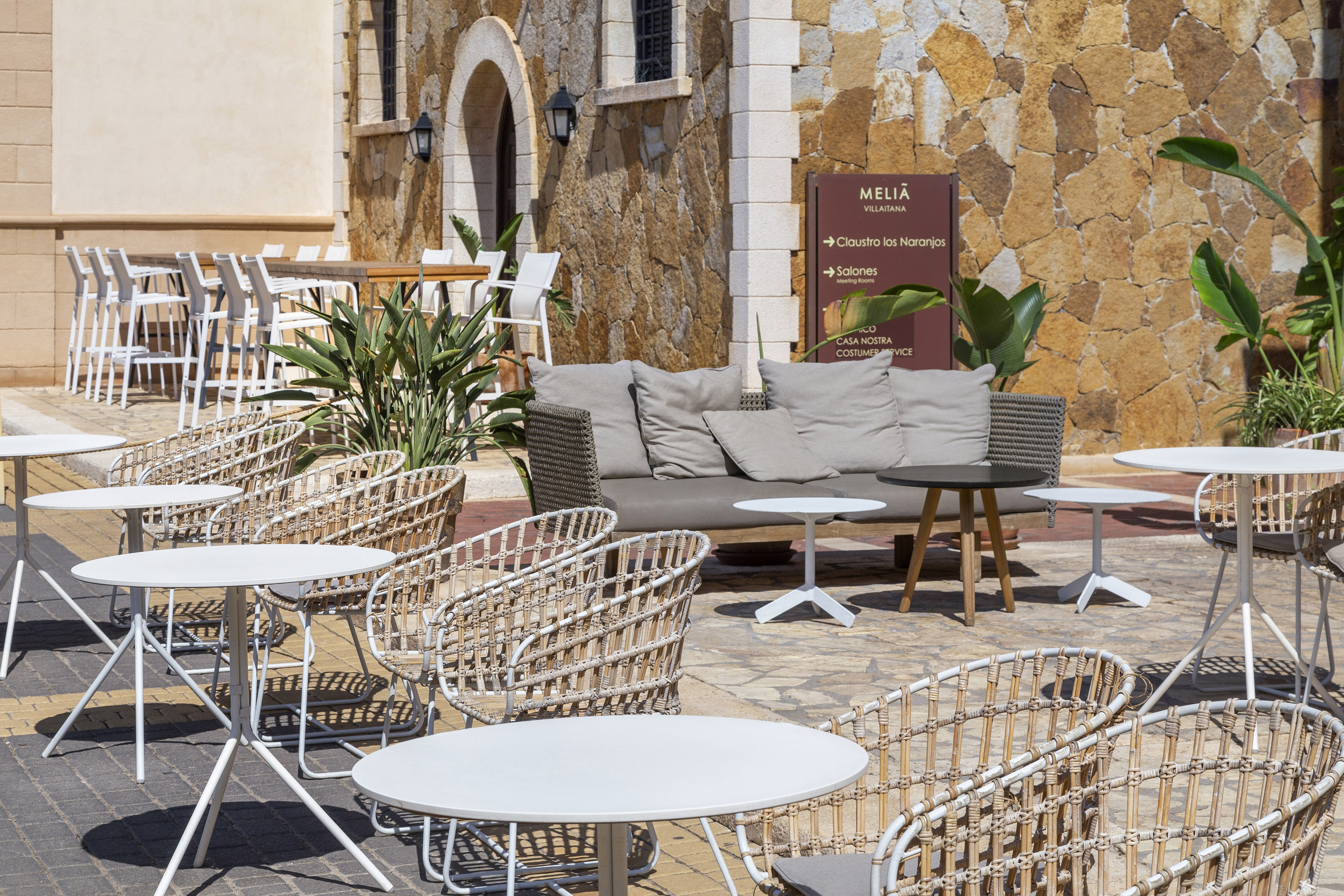Meliã Villaitana hotel outdoor terrace with wicker chairs and lounge seating.