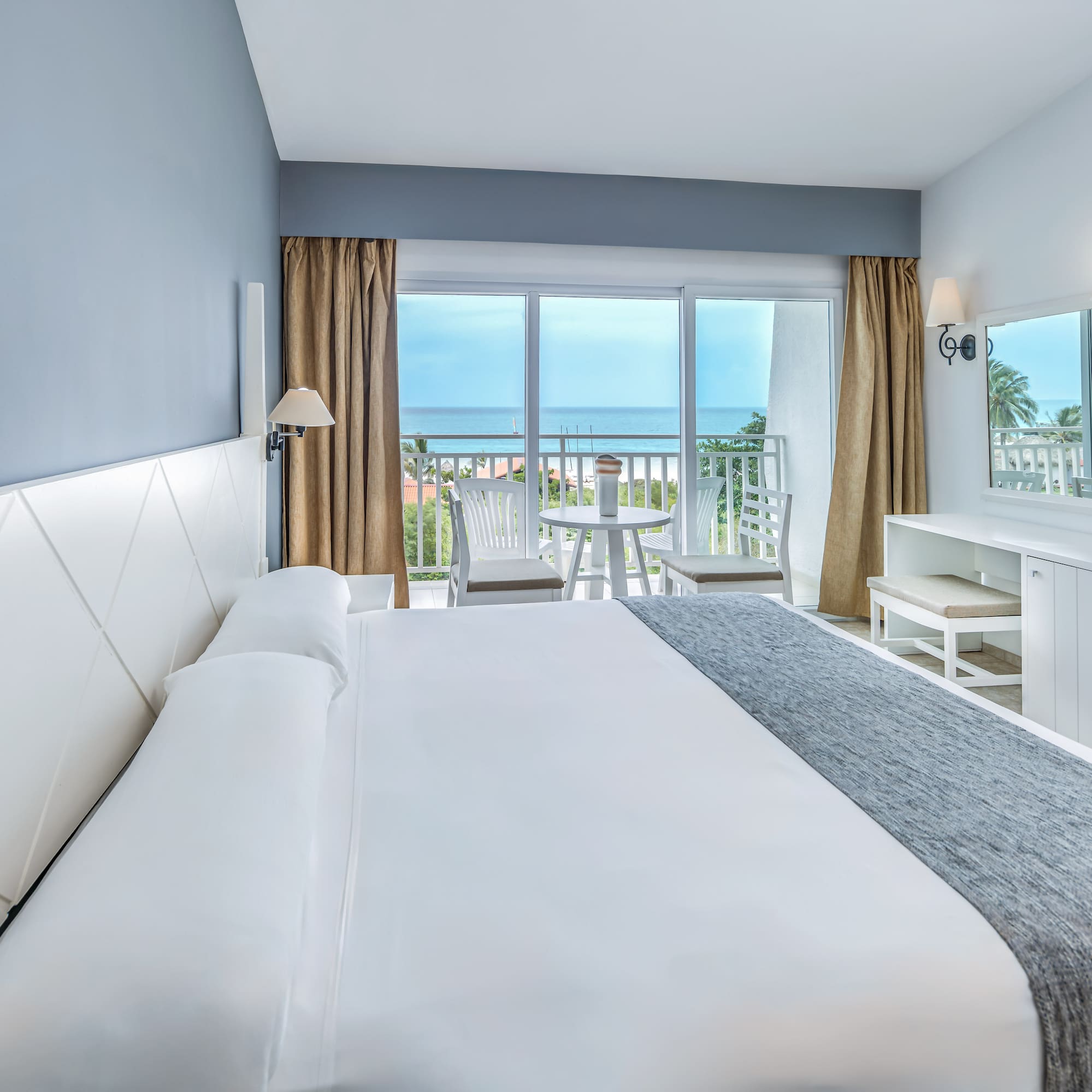 a bedroom with a large bed and a table and chairs