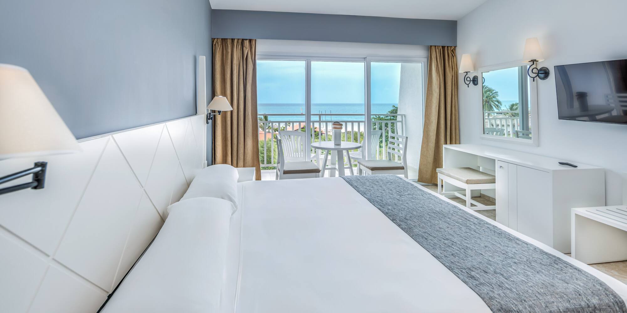 a bedroom with a large bed and a table and chairs