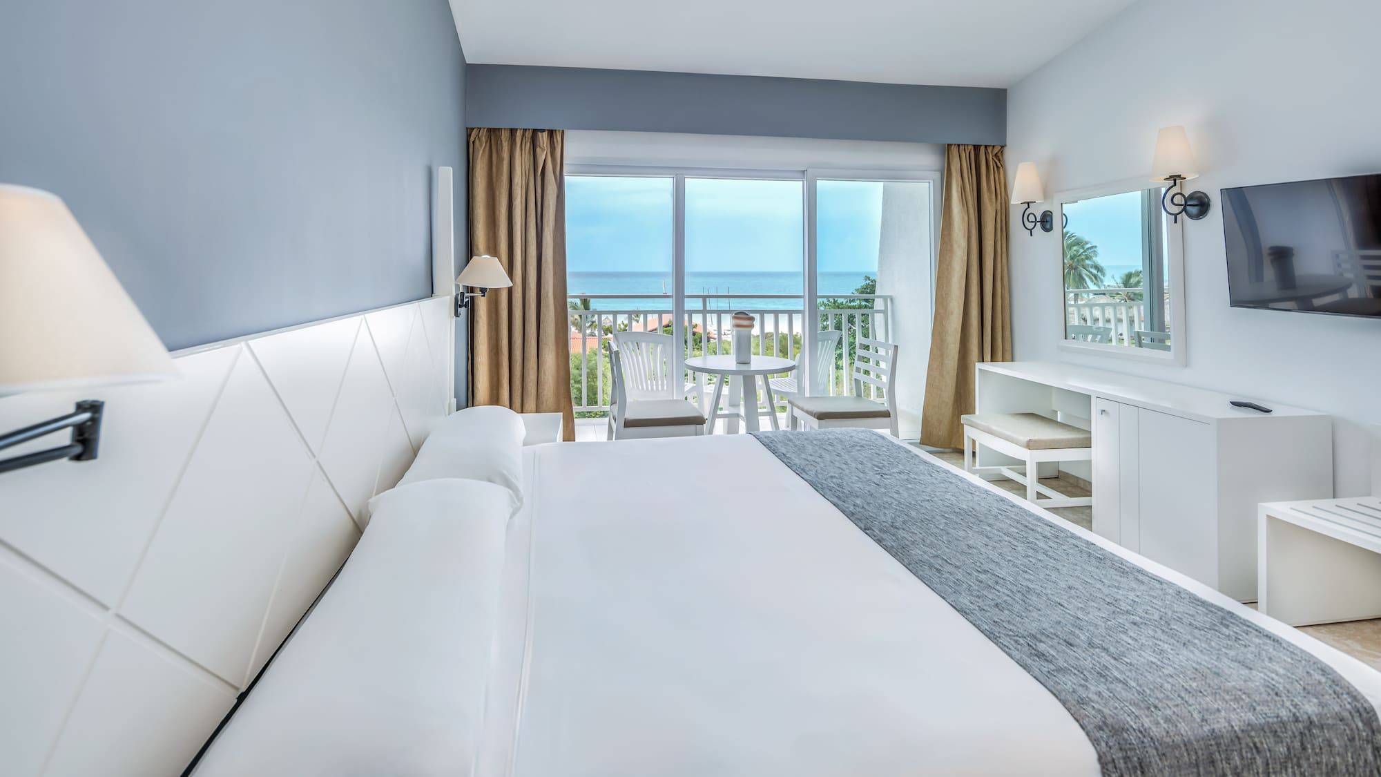 a bedroom with a large bed and a table and chairs