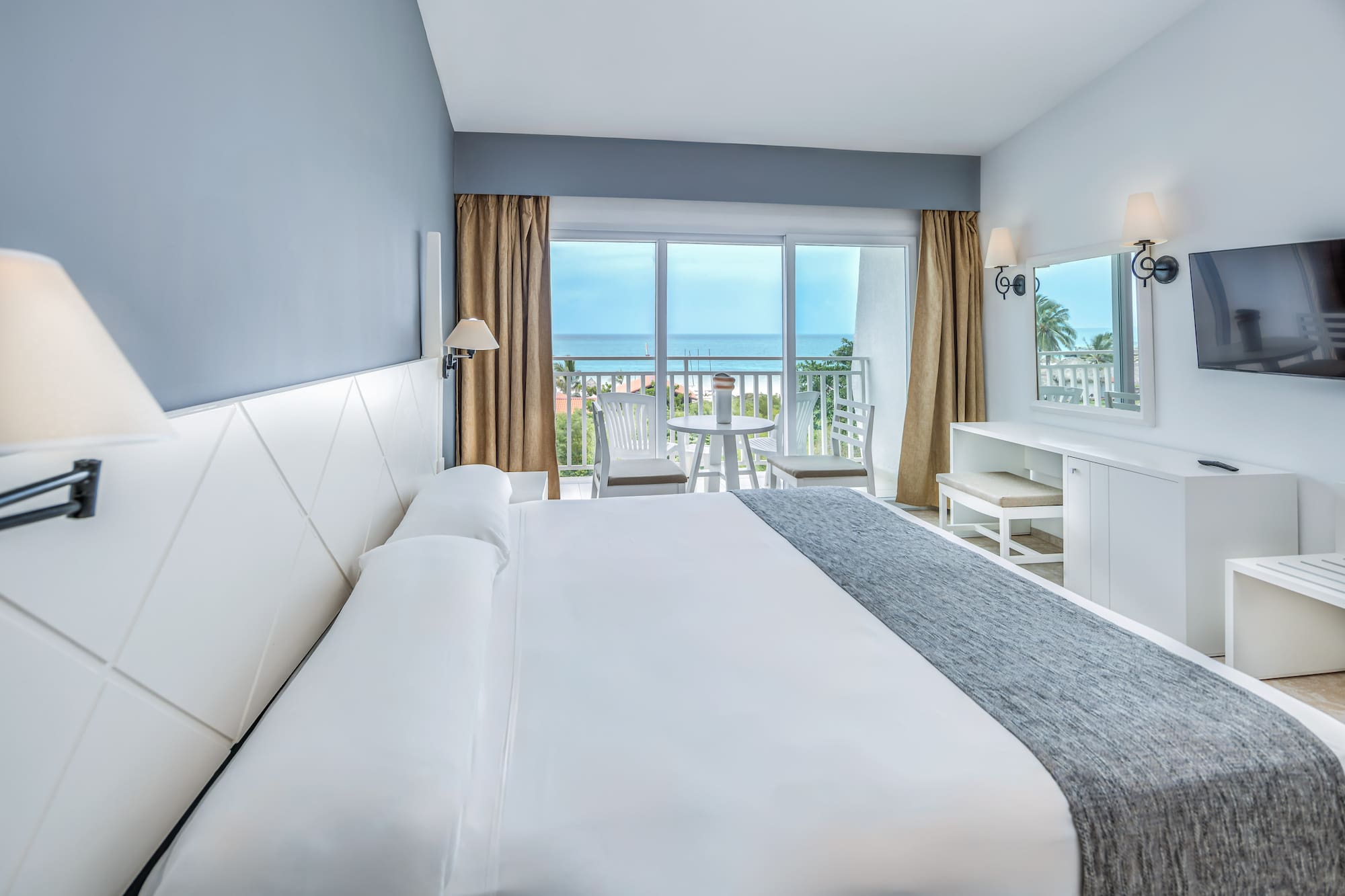 a bedroom with a large bed and a table and chairs