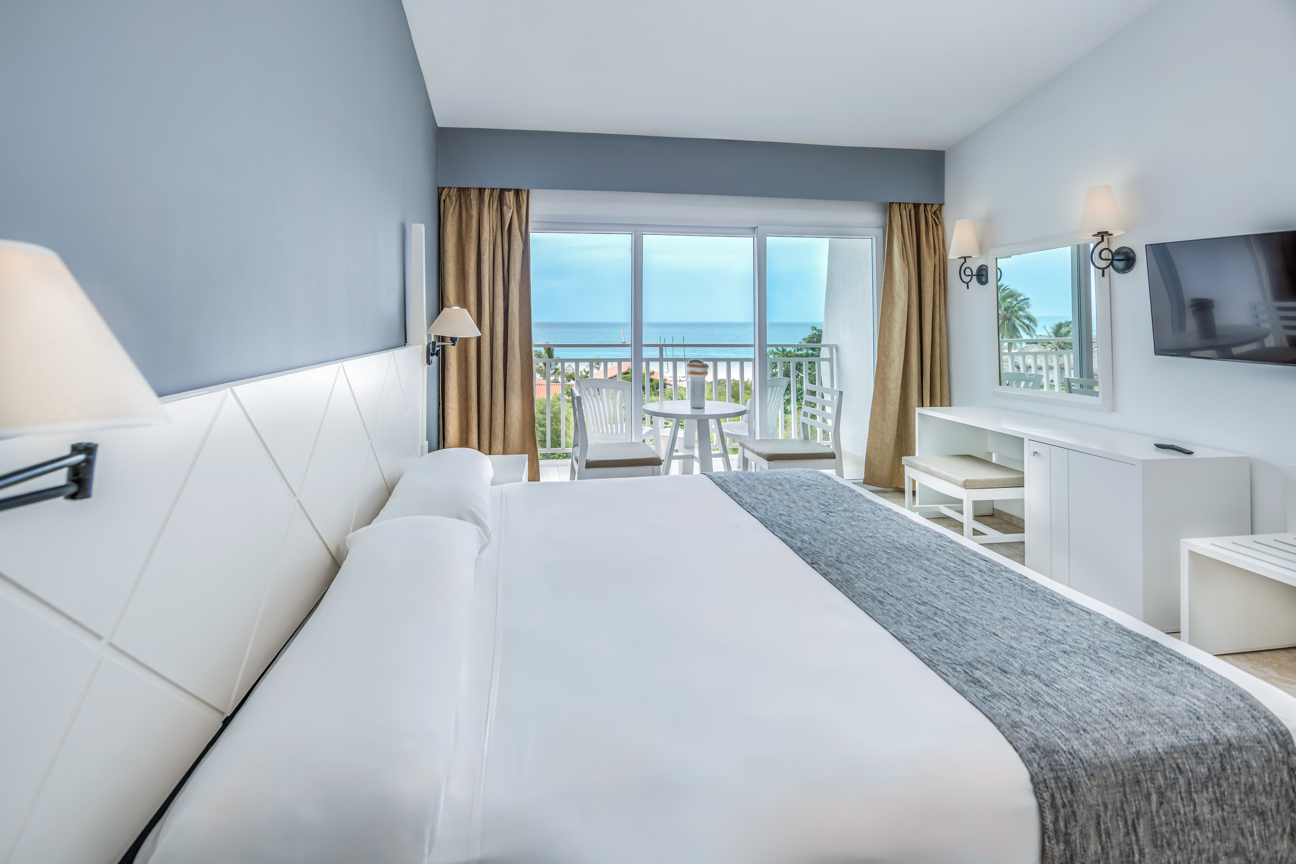 a bedroom with a large bed and a table and chairs