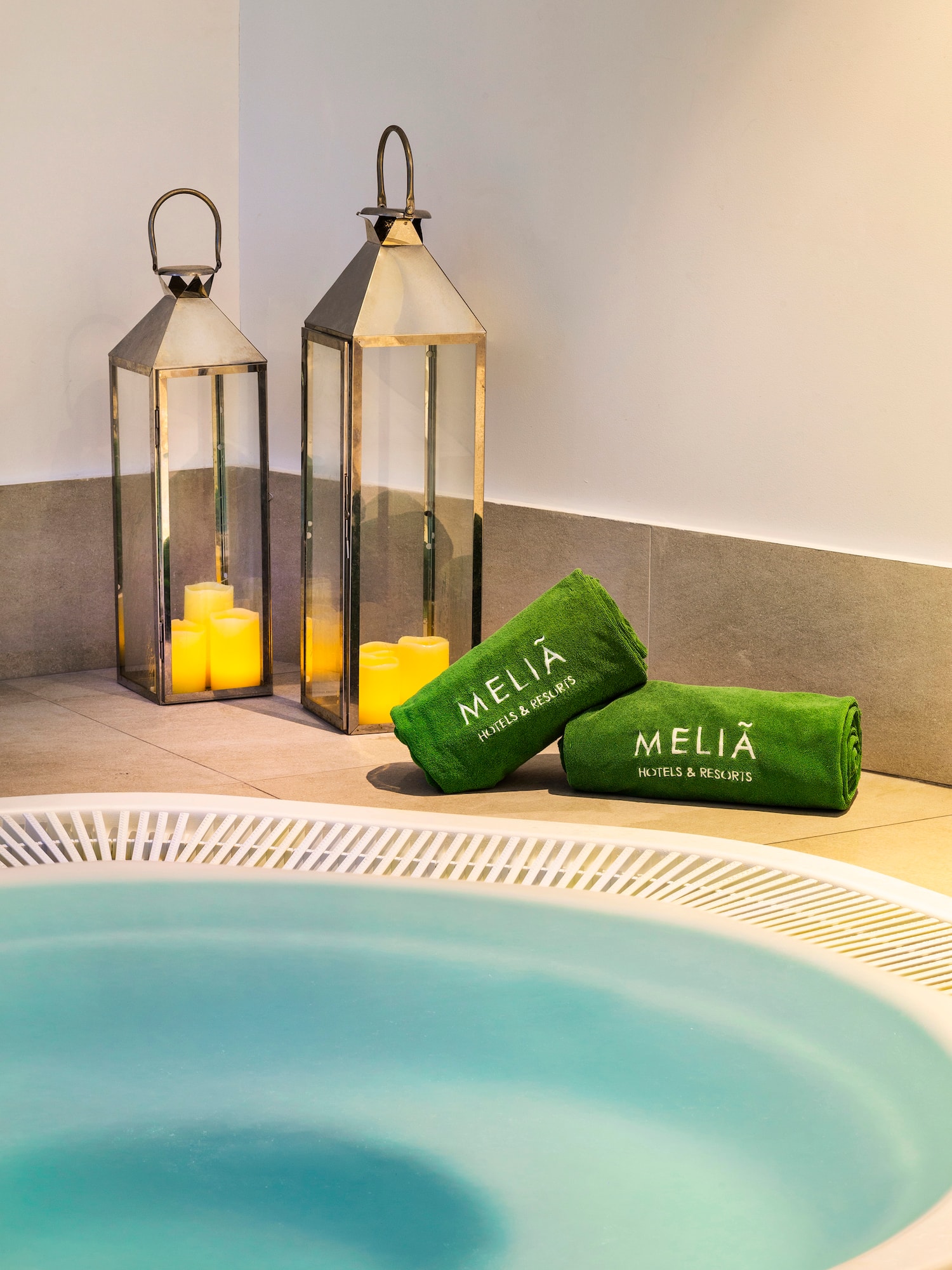 a hot tub with candles and towels