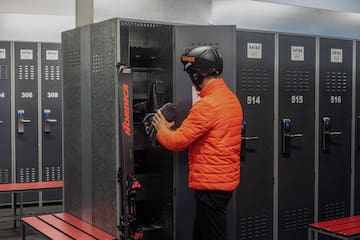 a man wearing a helmet and standing in front of lockers