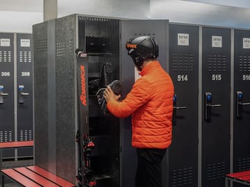 a man wearing a helmet and standing in front of lockers