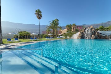 a pool with a waterfall and palm trees