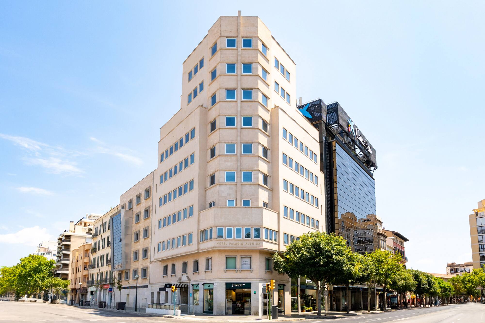 Hotel Palacio Avenida building on a sunny city street corner.