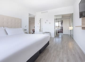 a white bedroom with a bed and wood floor