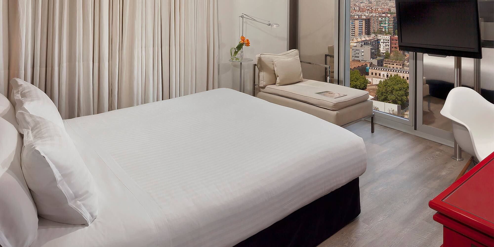 a bedroom with a large window and a bed