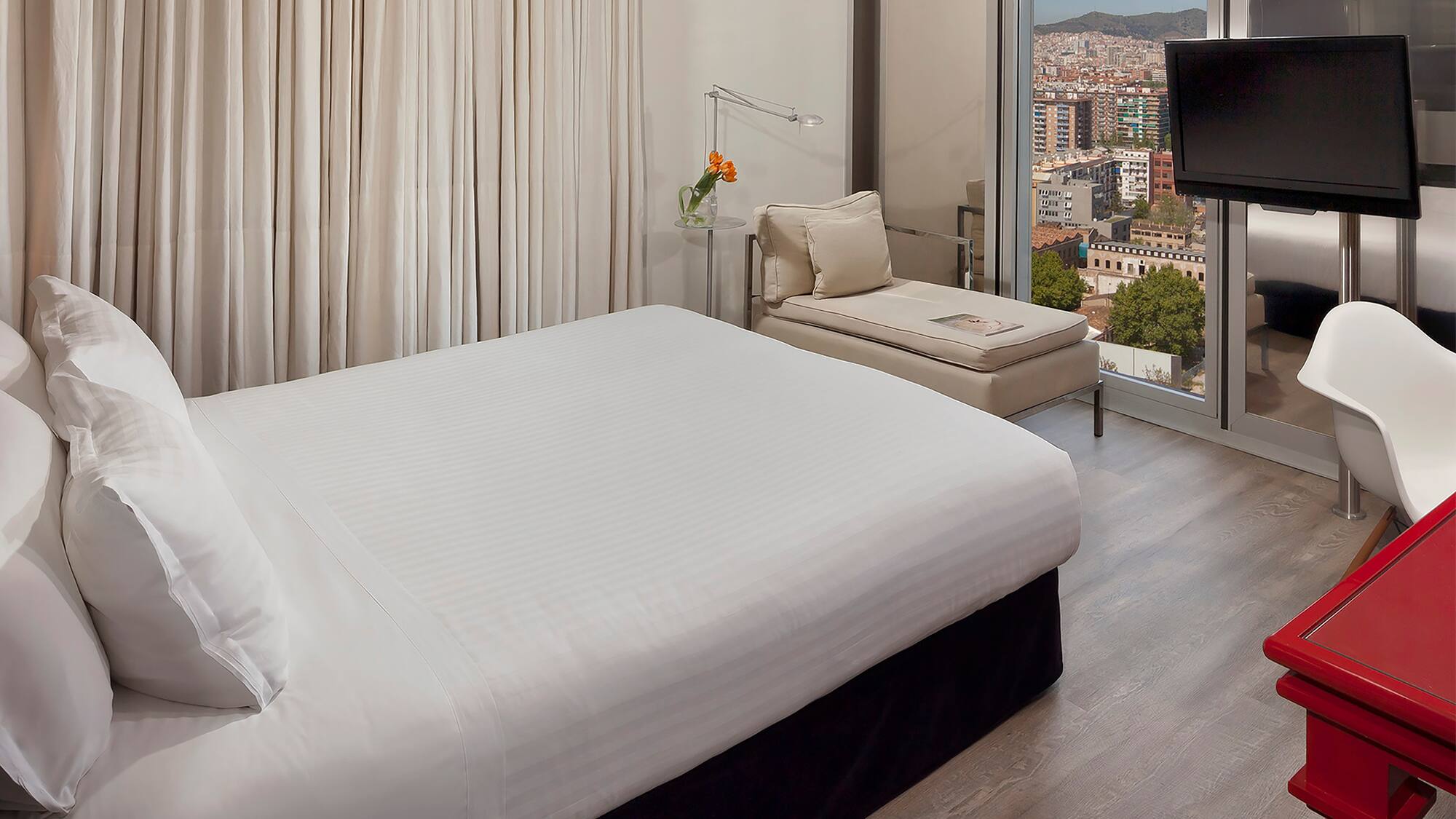 a bedroom with a large window and a bed