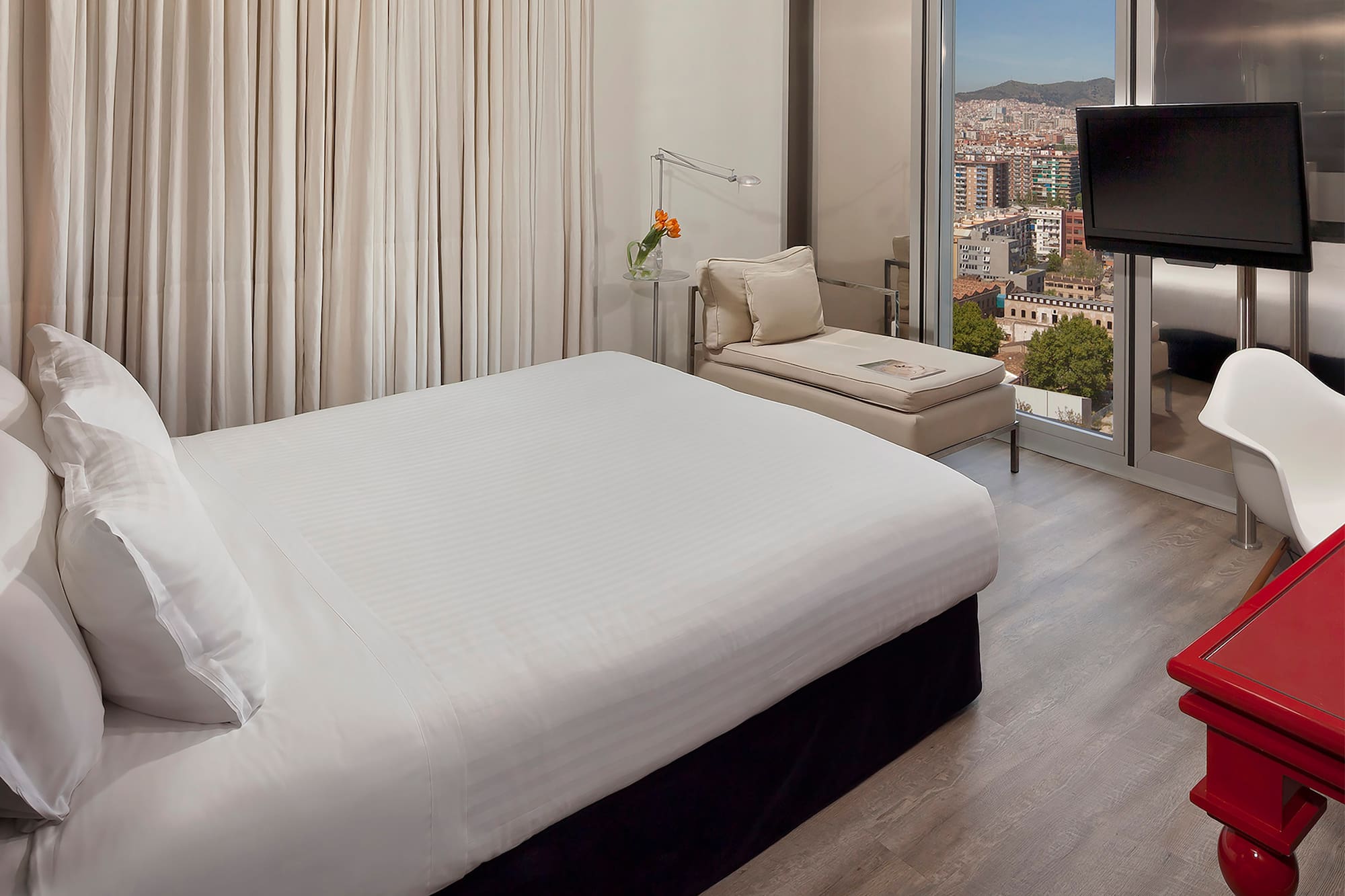 a bedroom with a large window and a bed