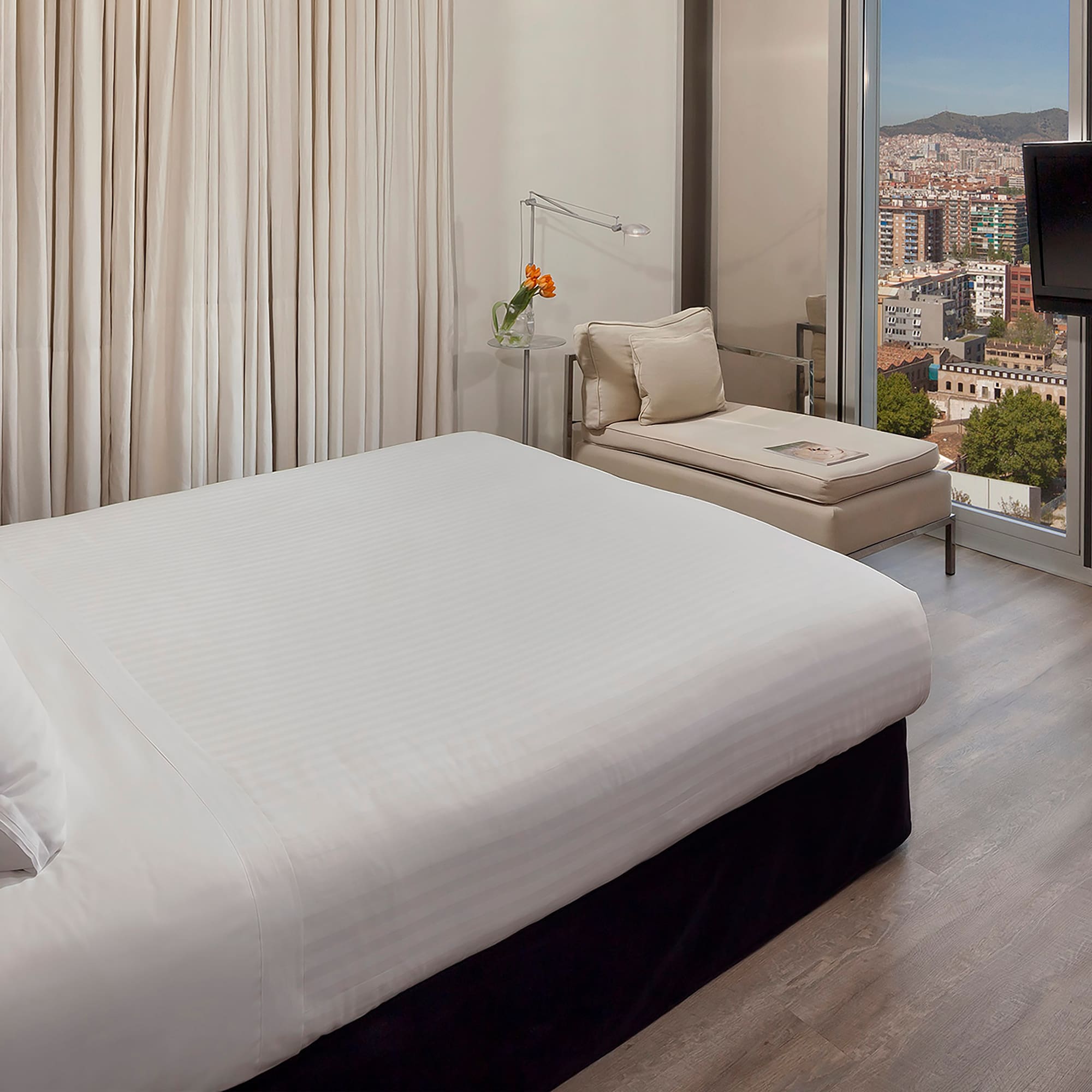 a bedroom with a large window and a bed